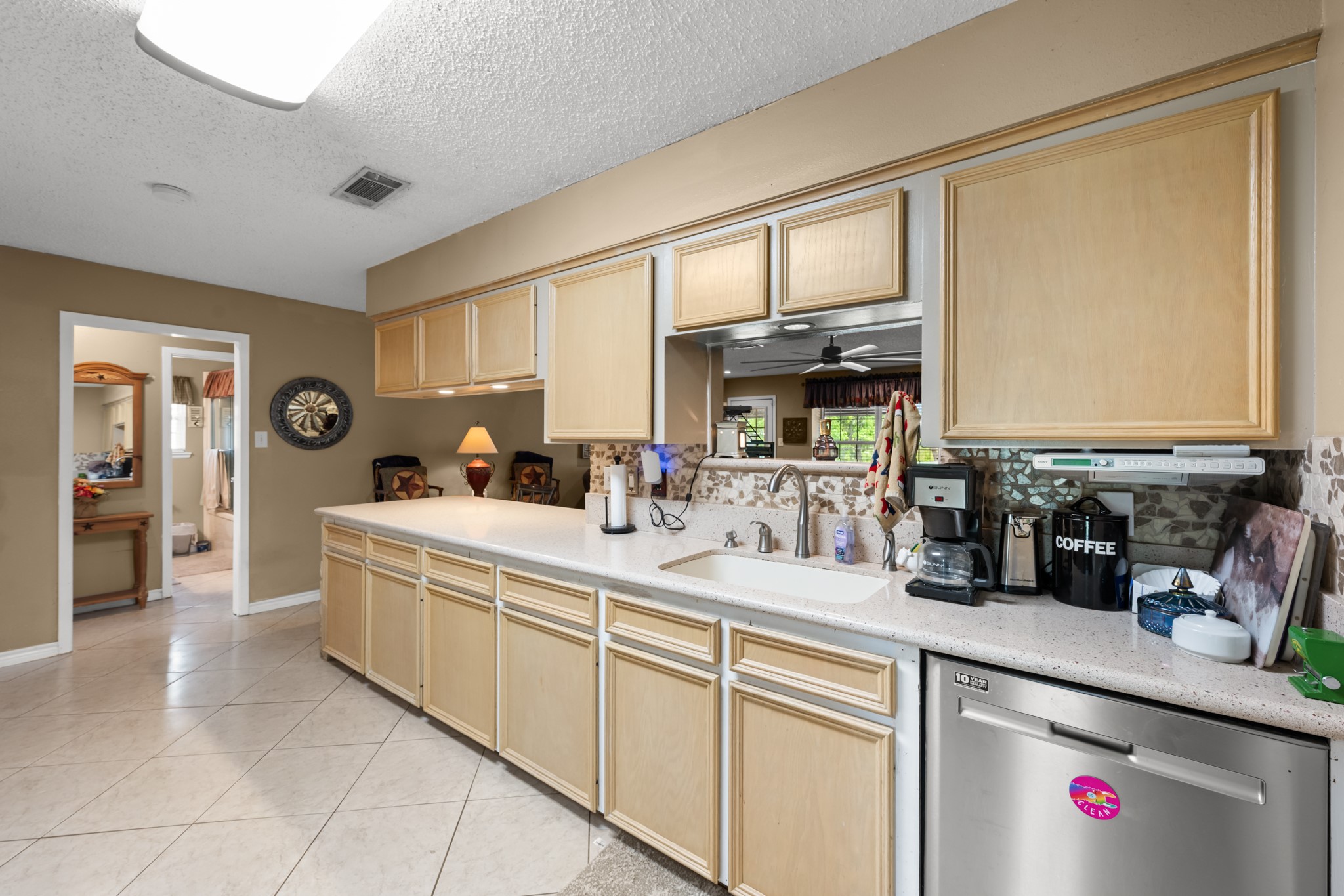 Spacious kitchen featuring extensive cabinetry, generous prep space, and a large peninsula overlooking the main living area. Stainless steel appliances, tile flooring, and an open layout provide both functionality and everyday convenience.