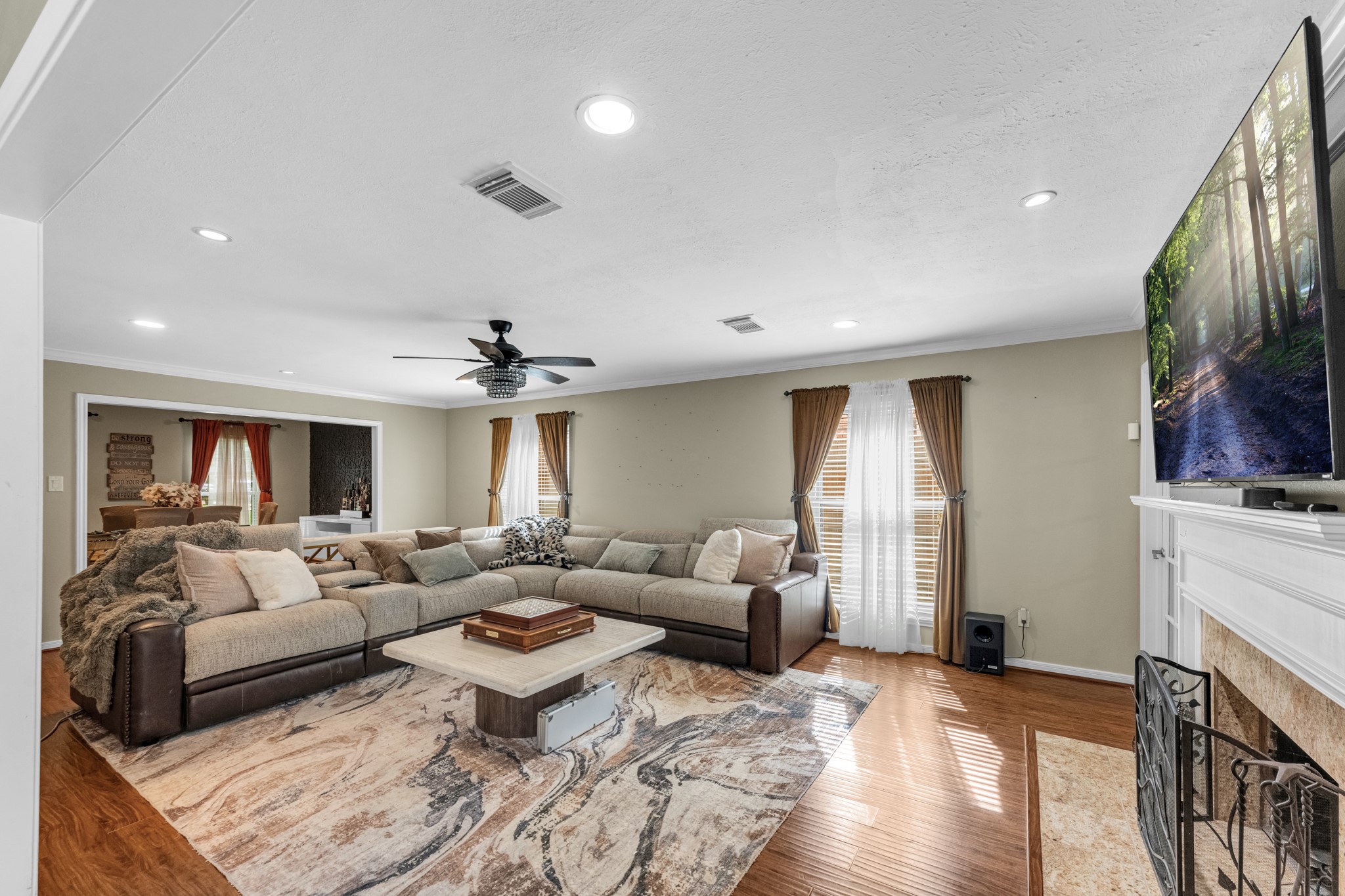 The family room offers an inviting, oversized layout centered around a beautiful fireplace, creating the perfect space for relaxing evenings or gathering with family and friends.
