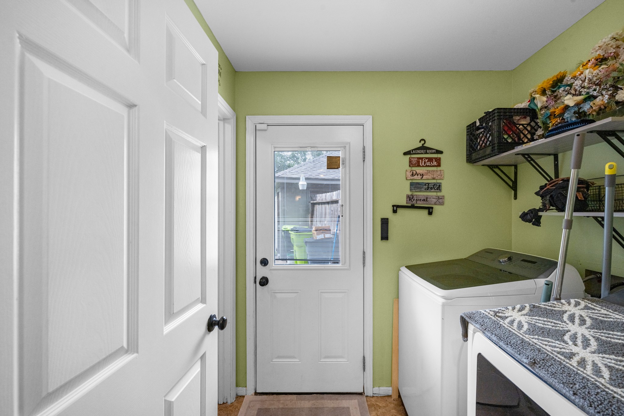 Laundry room with guest bathroom off the kitchen with access to the backyard.