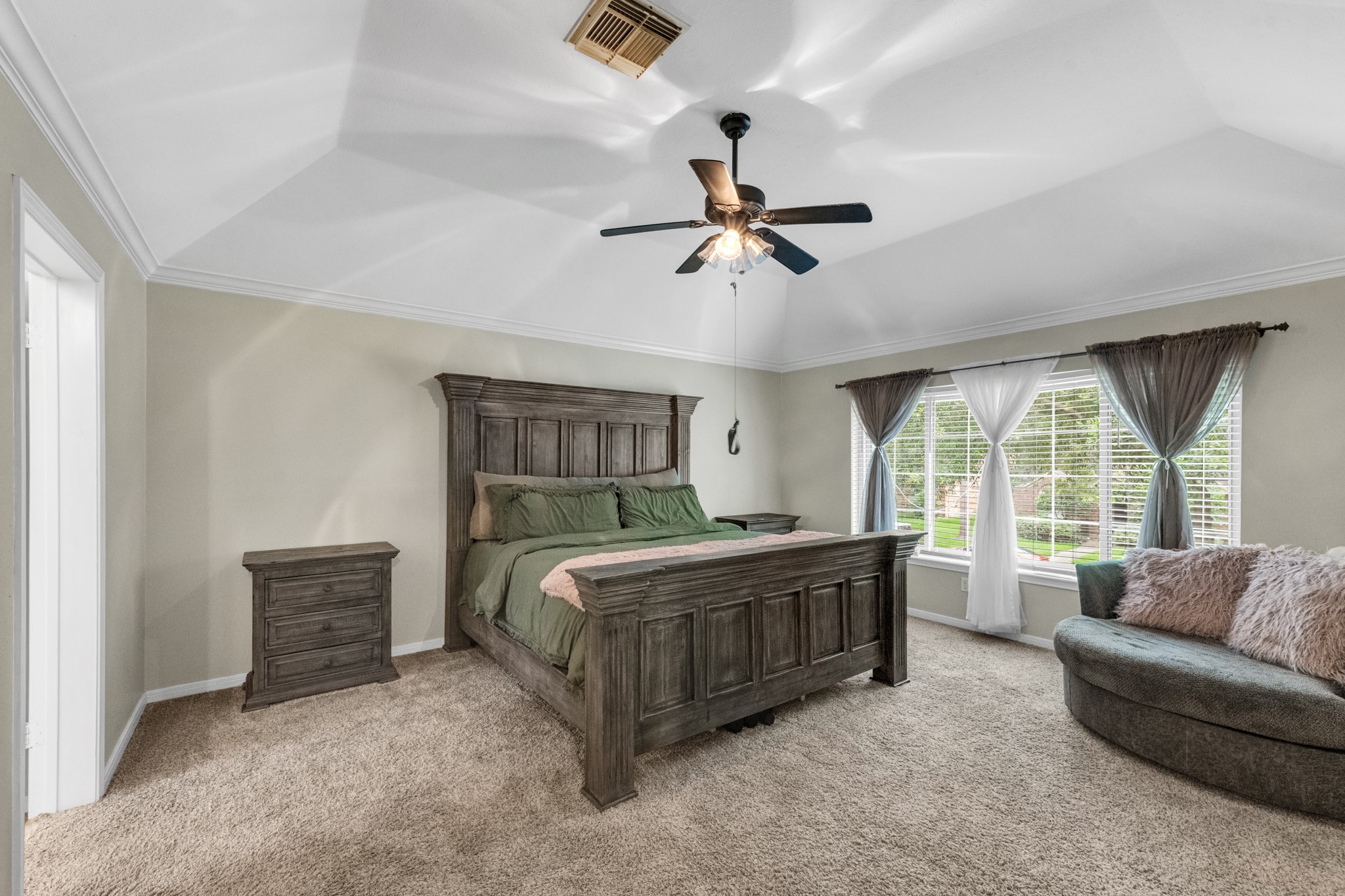 The spacious primary suite features soaring ceilings, abundant natural light, and a bright, airy feel that creates the perfect private retreat.