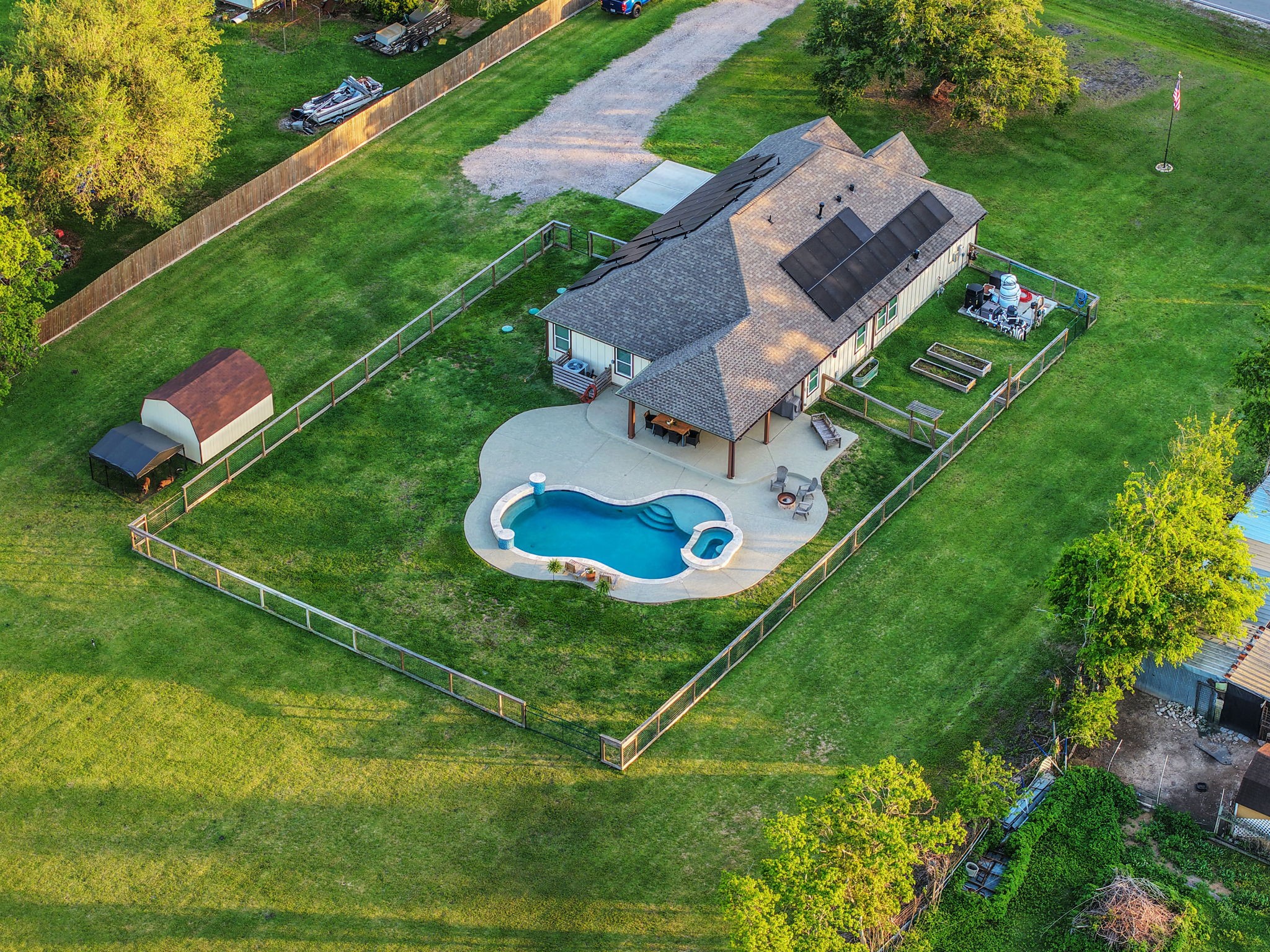 Expansive fenced property featuring a charming home complemented by a luxurious pool and a spacious patio, ideal for outdoor relaxation and entertaining.