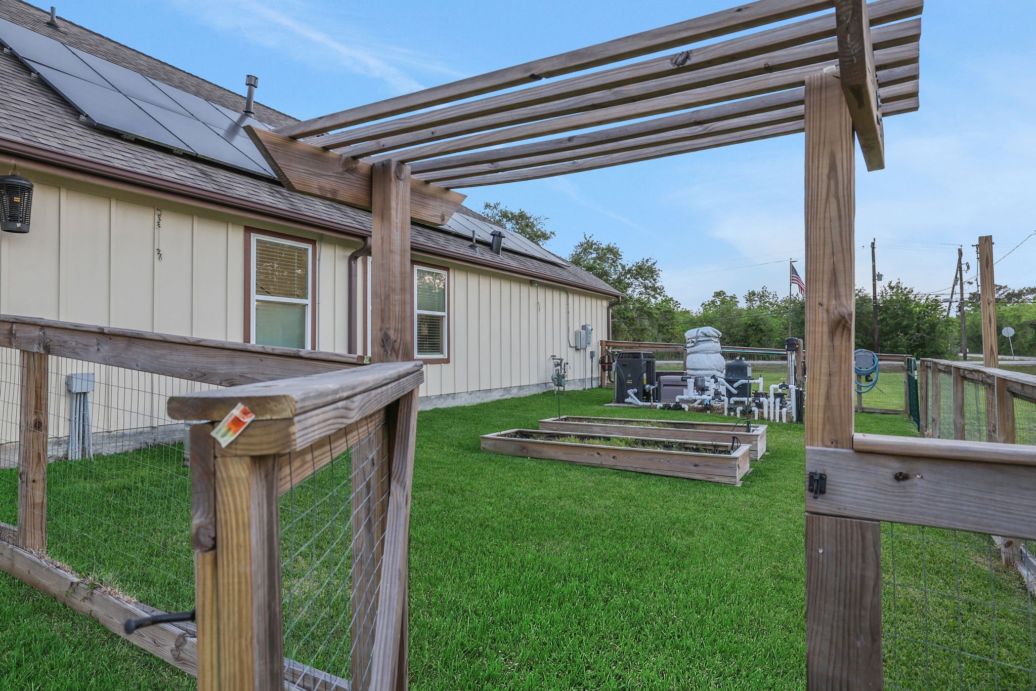 Charming fenced area features a wooden entry to a well-maintained green space for your home garden.
