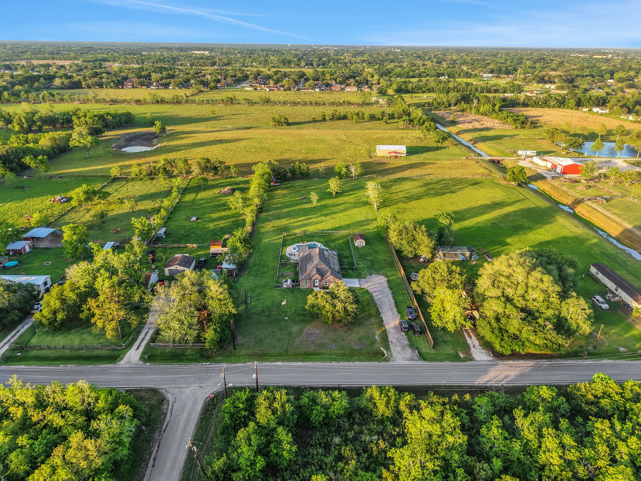 Expansive property with a charming home set amidst lush greenery and open fields, offering privacy and serene country living.