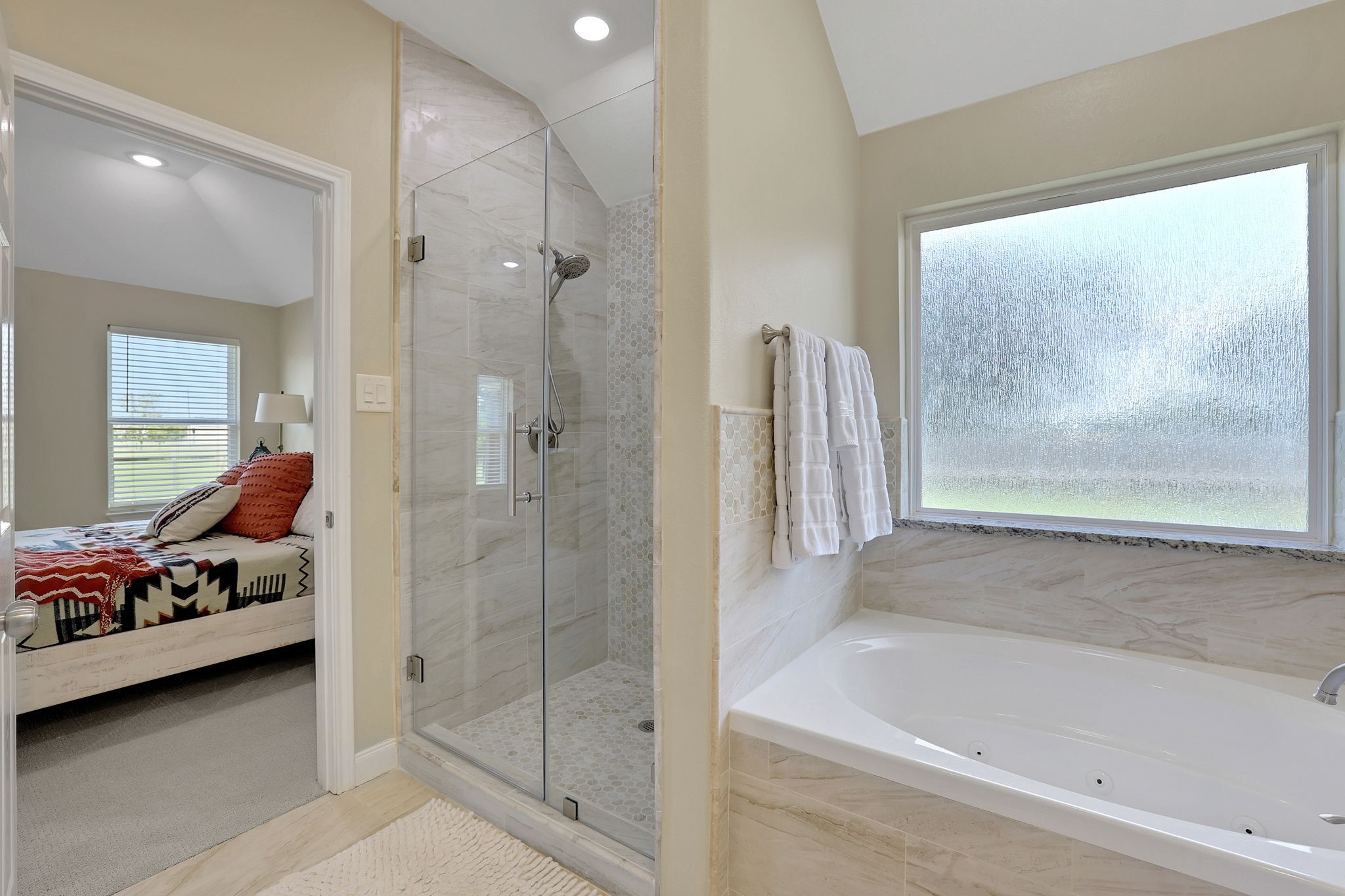Freshly updated primary bath with a new tile surround that feels like a true spa retreat