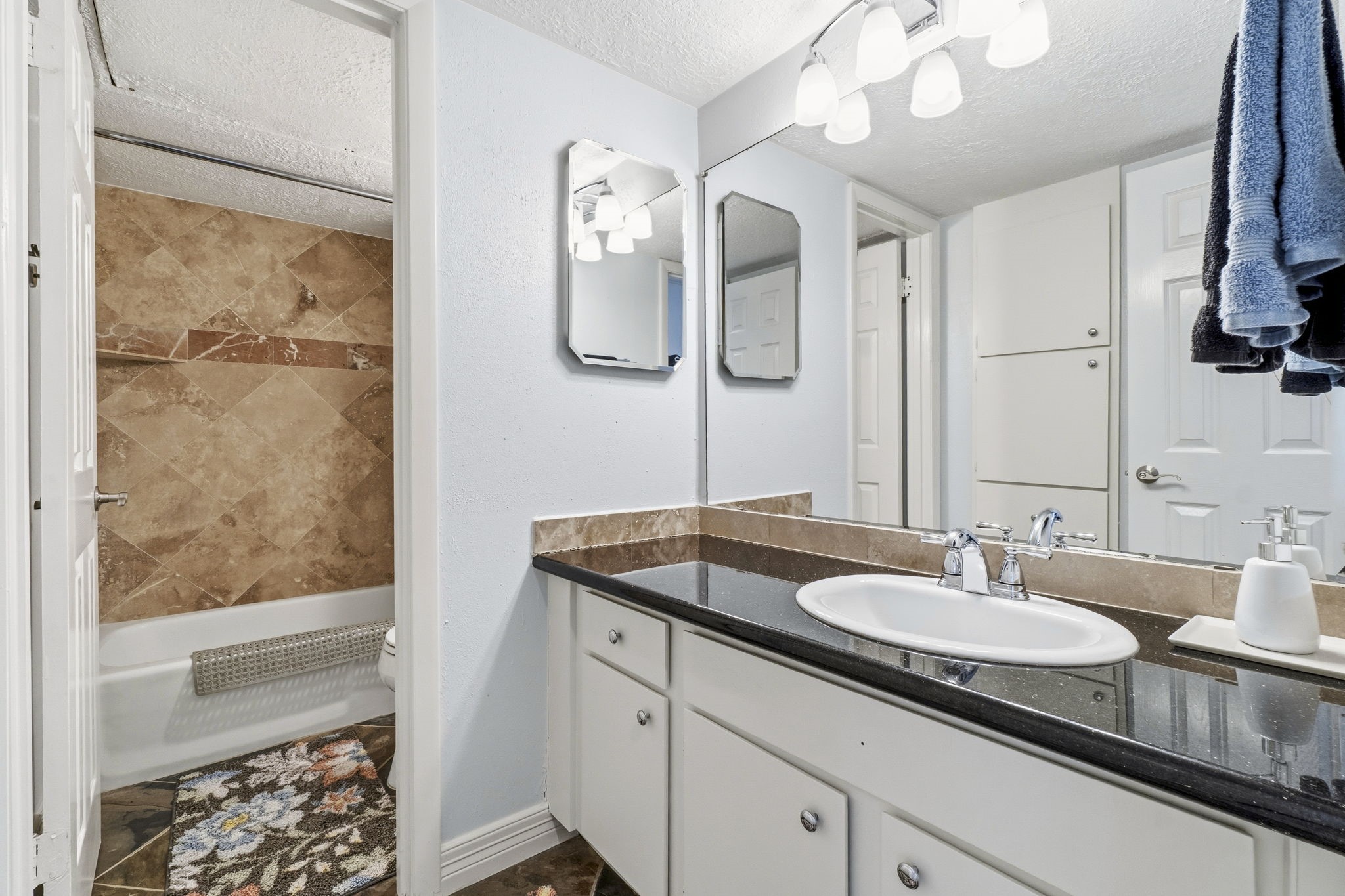 Secondary Full Bathroom Well-appointed bath with granite countertops, ample storage, and attractive finishes.