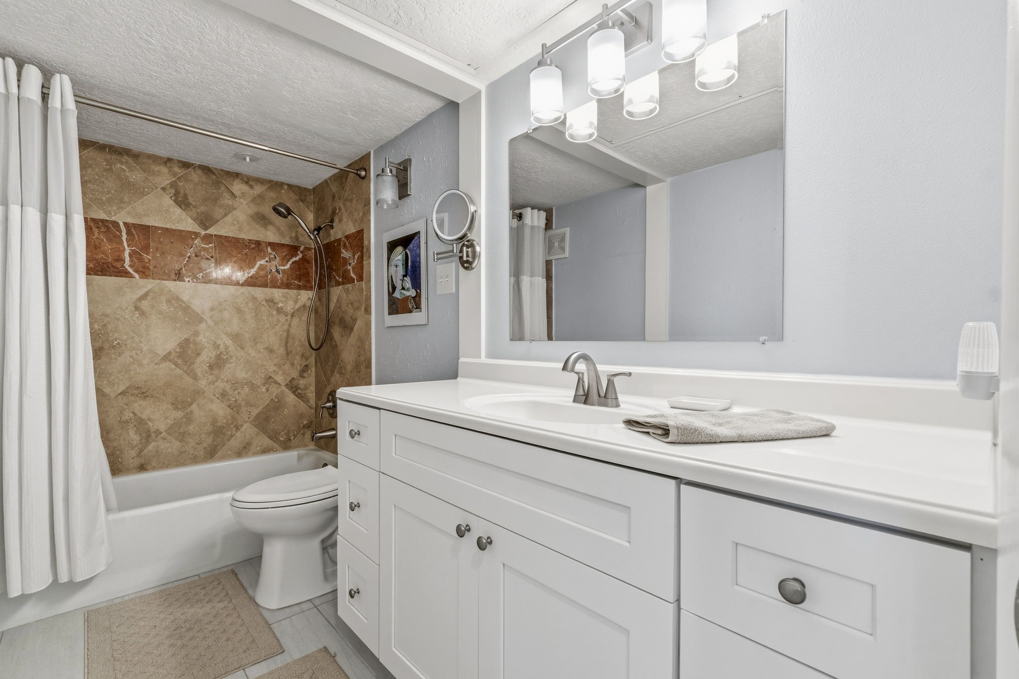 Updated Primary Bathroom Beautifully remodeled bath featuring a modern vanity, updated fixtures, and elegant tile surround.