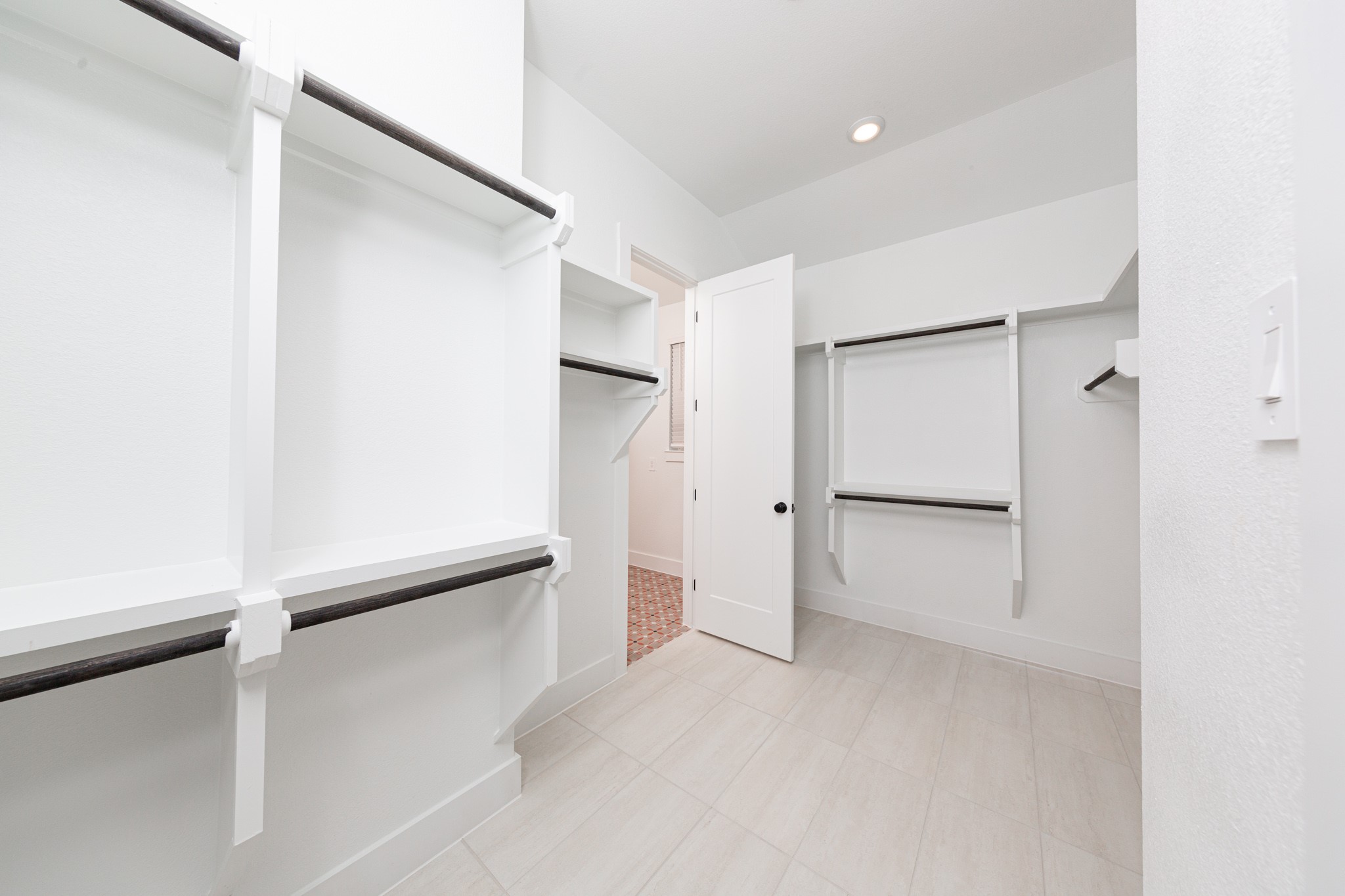 Look at this immaculate closet! With high shelving, multiple rows to hang clothing, you are sure to have enough room for all your belongings! This closet also features a convenient access door directly into the laundry room.