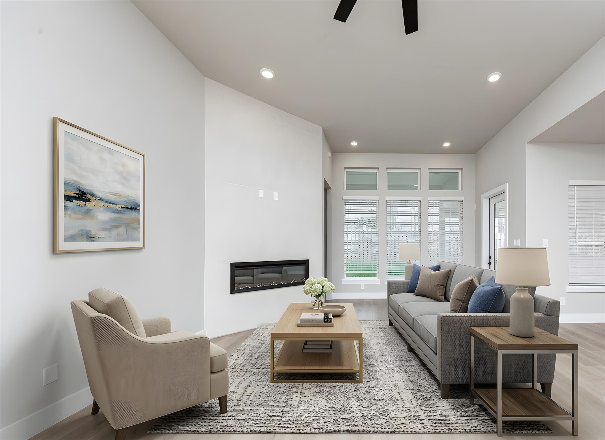 The open and airy Family Room is designed for seamless entertaining and showcasing striking architectural details with large tall windows, high ceilings with ceiling fan, recessed lighting, a beautiful electric fireplace, and durable flooring. *Virtually Staged