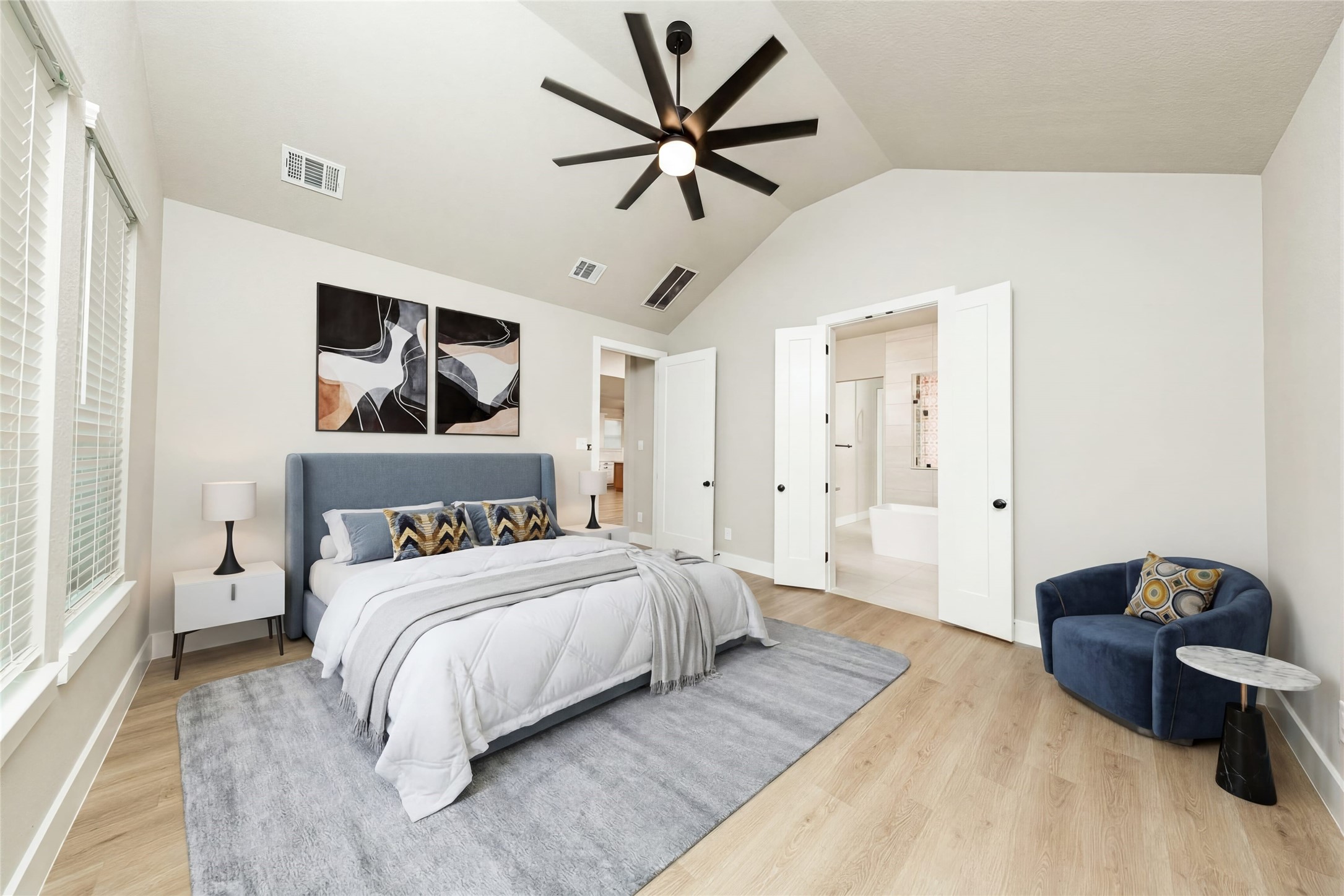 Relax and unwind after a long day in this impressive primary suite! This generously sized room offers the same wood-look flooring, neutral-toned paint, cathedral ceilings with a ceiling fan, and large windows for added comfort and tranquility. *Virtually Staged