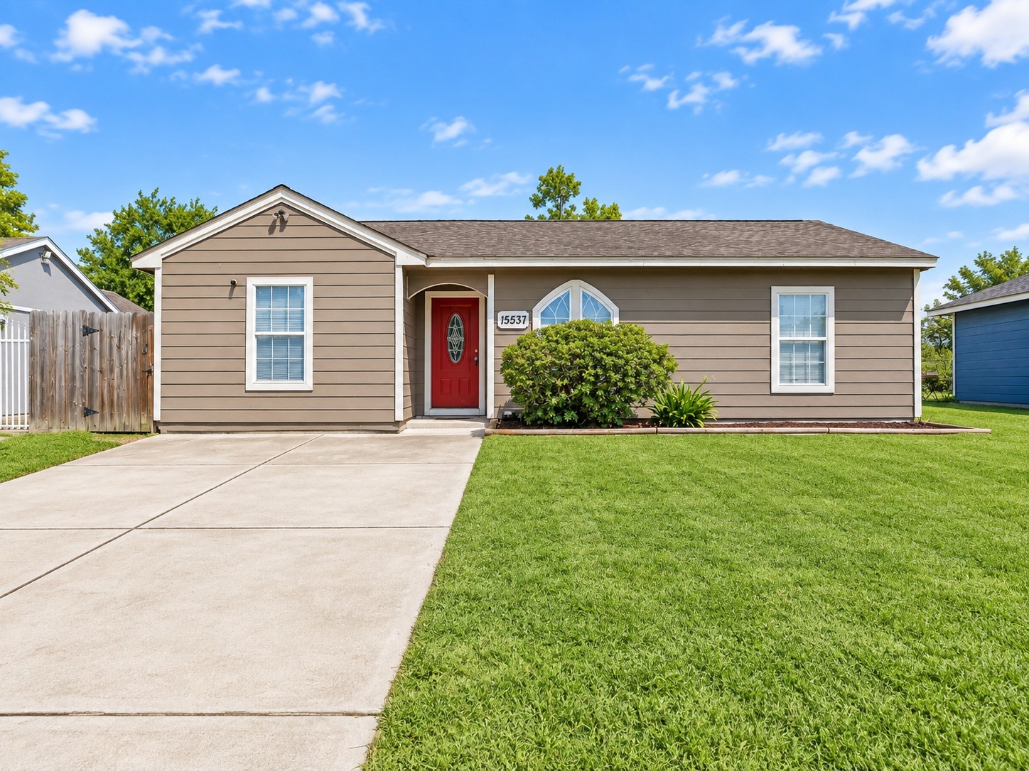 Charming curb appeal welcomes you home with a bold red front door, lush green lawn, and a wide driveway with plenty of parking. Charming curb appeal welcomes you home with a bold red front door, lush green lawn, and a wide driveway with plenty of parking.