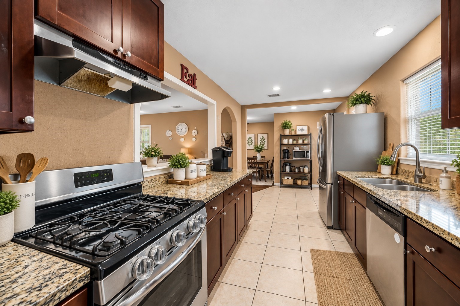 The stainless steel appliances and granite countertops in this kitchen make meal prep a breeze, with tile flooring that's as practical as it is stylish.