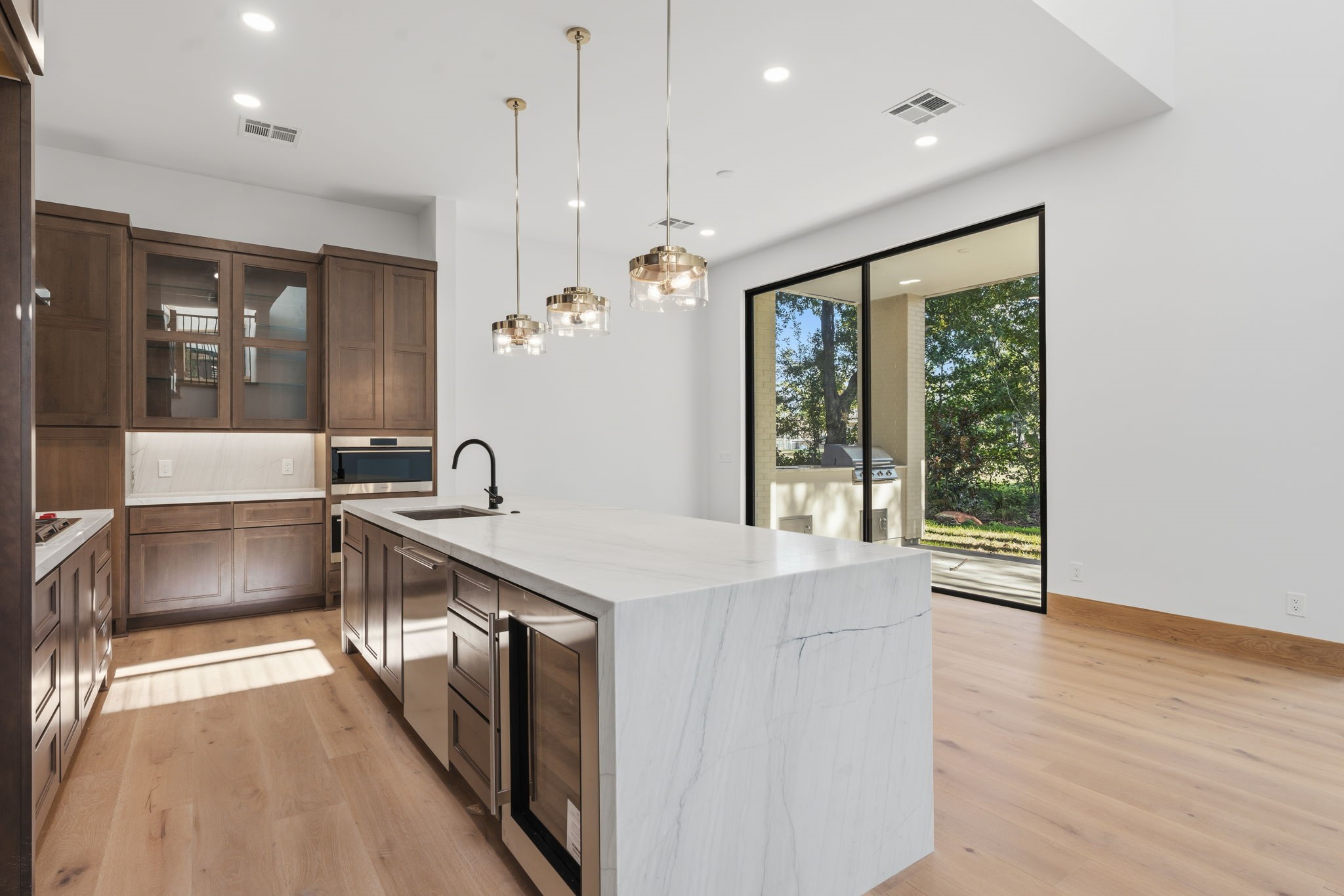 Gourmet kitchen w/ custom cabinetry, Wolf appliances, waterfall quartz island, beverage fridge & wall-of-glass sliding door to golf course views! Gourmet kitchen w/ custom cabinetry, Wolf appliances, waterfall quartz island, beverage fridge & wall-of-glass sliding door to golf course views!