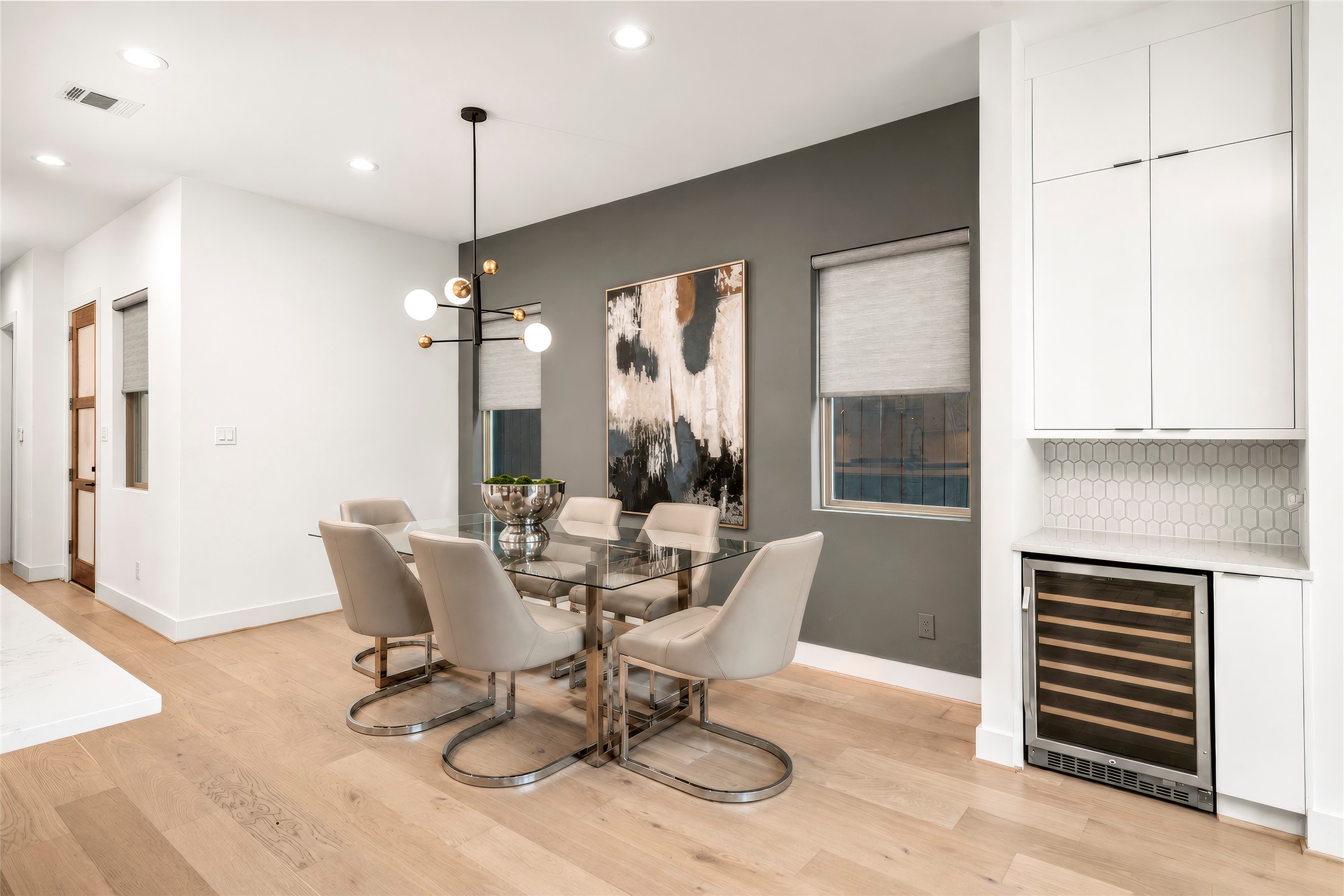 Dining Room with accent painted wall and designer light fixture and recessed lighting.  Two windows bringing in natural light.  Custom shades!  Virtually rendered.