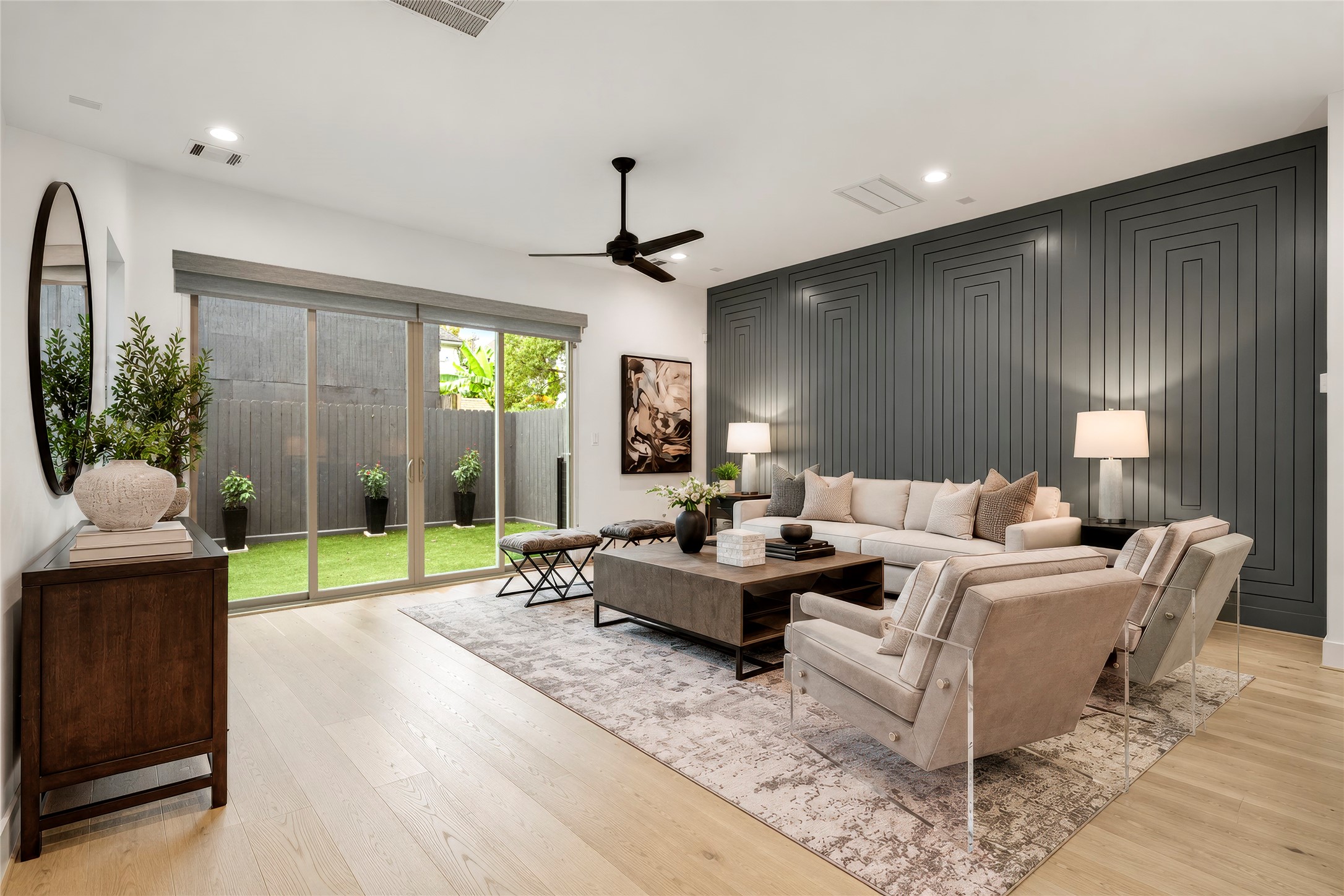 Another perspective of the living room with sliding glass doors to the backyard.  Amazing custom designer millwork on the North wall.  Virtually rendered.