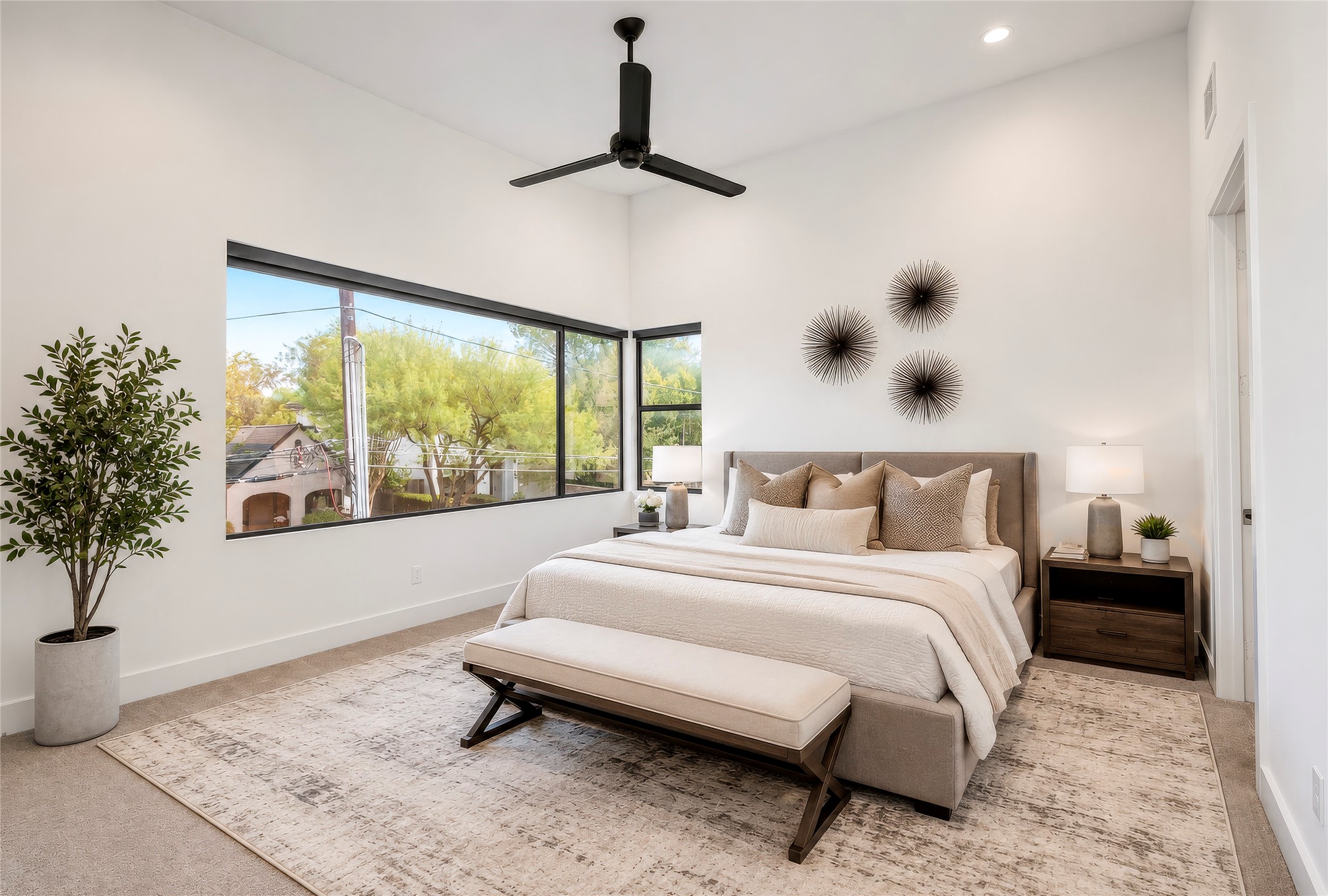 Welcome to the luxurious primary suite.  High ceilings, ceiling fan, carpet - expansive windows with a view to the east towards downtown.  Custom shades installed.  Virtually rendered.