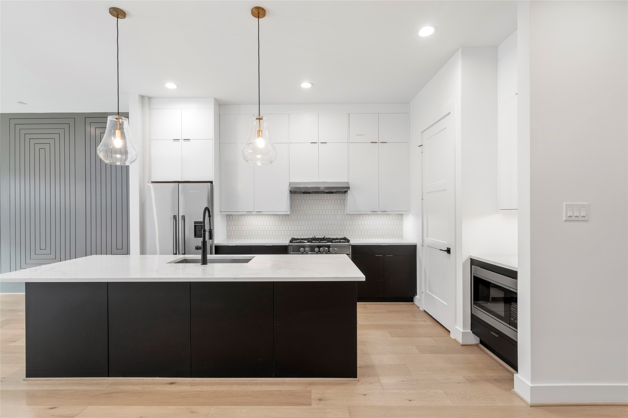 Chef's Kitchen with oversized island.  Designer selected contrasting cabinetry with seasonal storage to the ceiling.  Quartz counter tops.