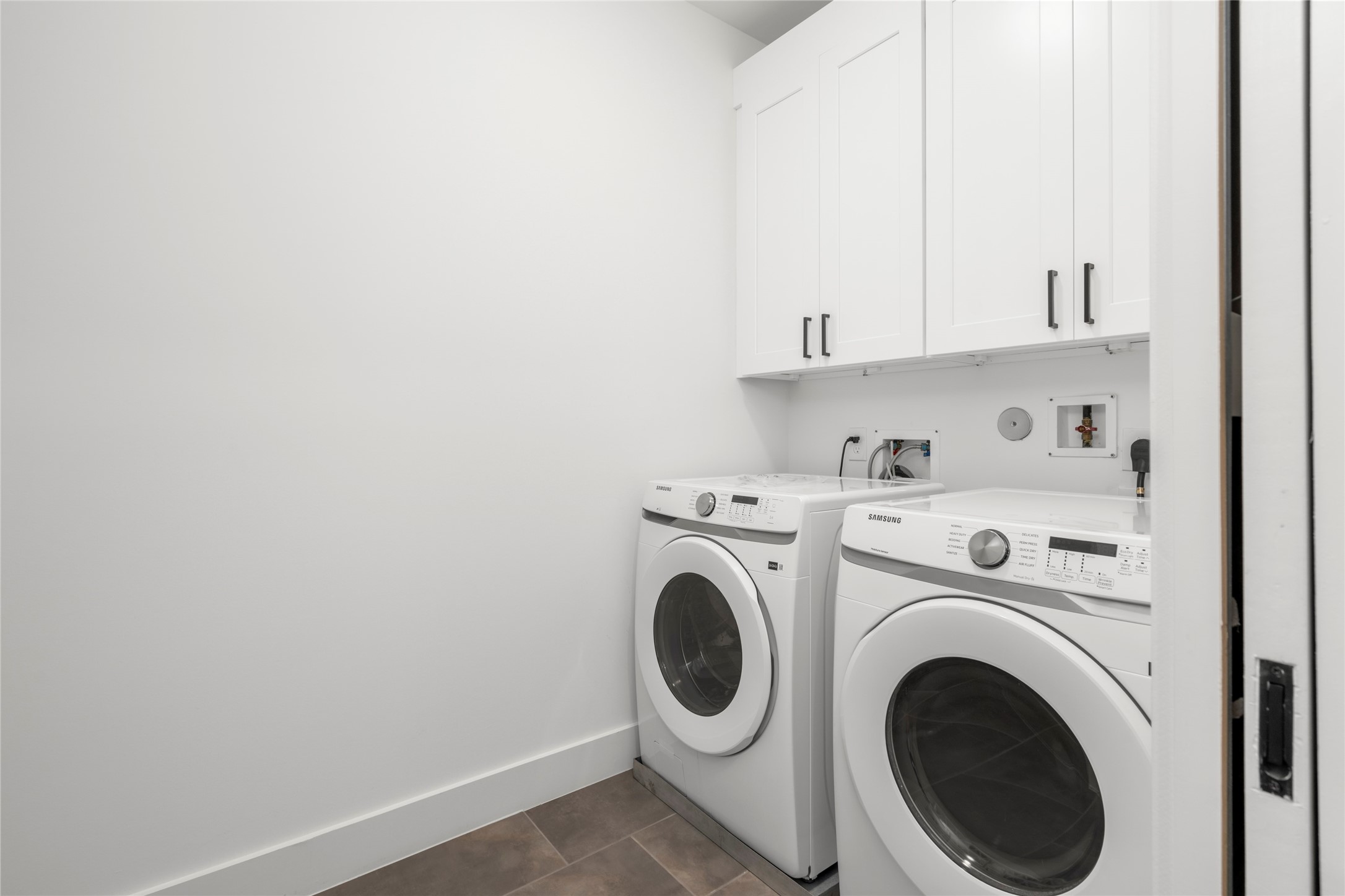 The utility room is centrally located on the second floor with lots of room and built in storage.  Samsung washer and dryer convey with the home!
