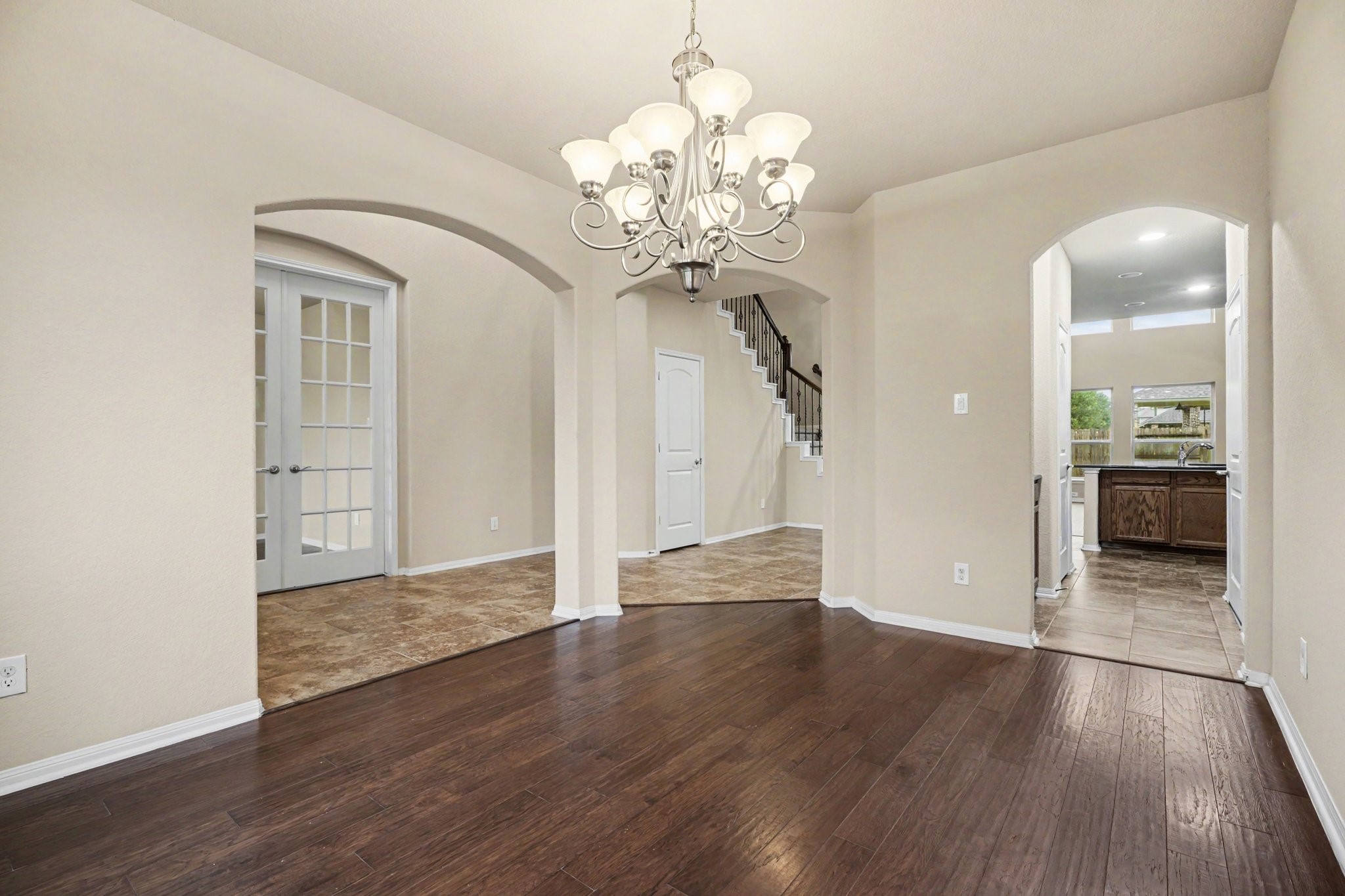 The architectural details include arched walkways and double French doors, plus convenient access to the kitchen!