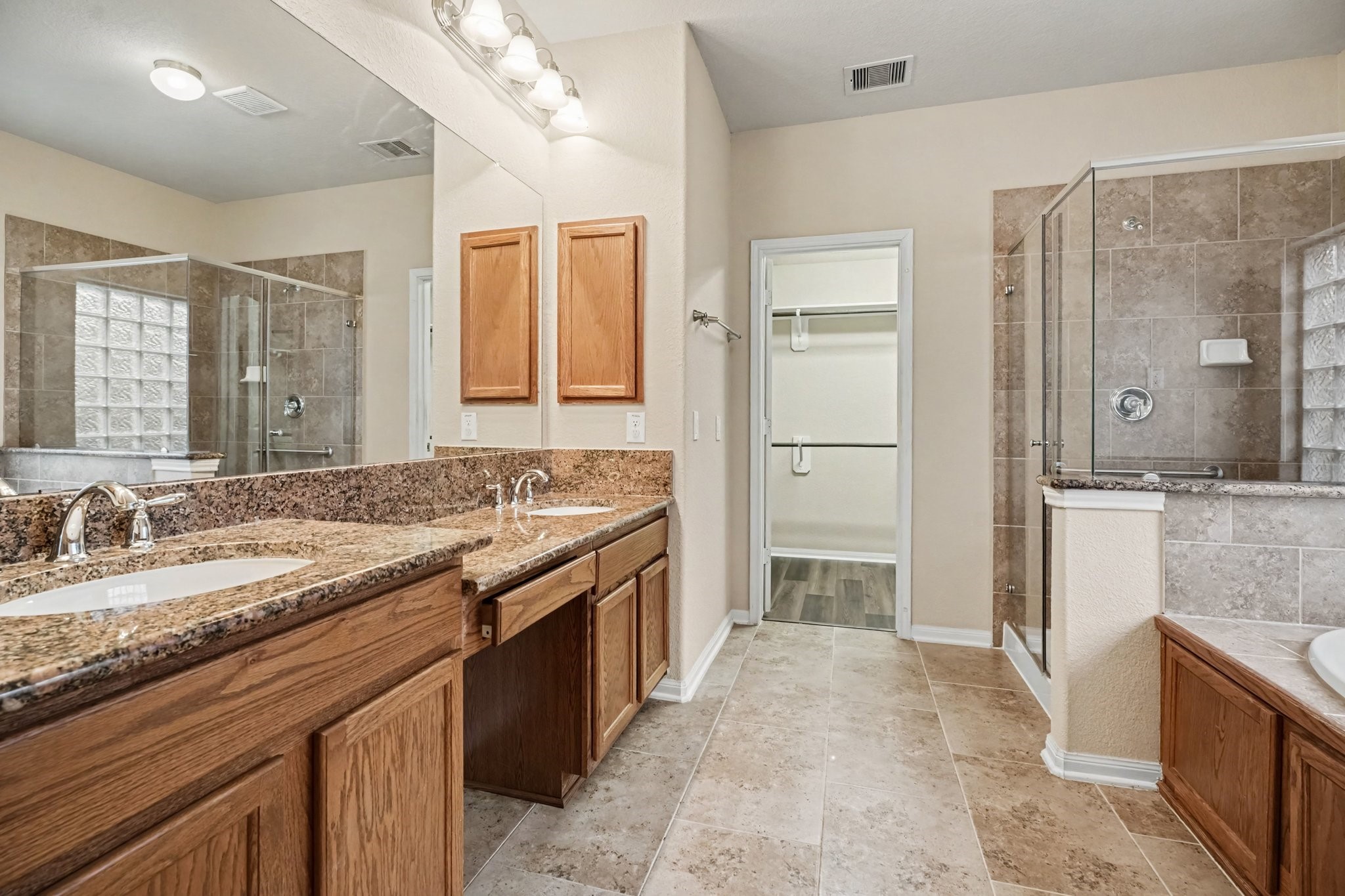 An ensuite bath features dual sinks, one raised and one with knee space, providing a place to gather your thoughts before heading out for the day!