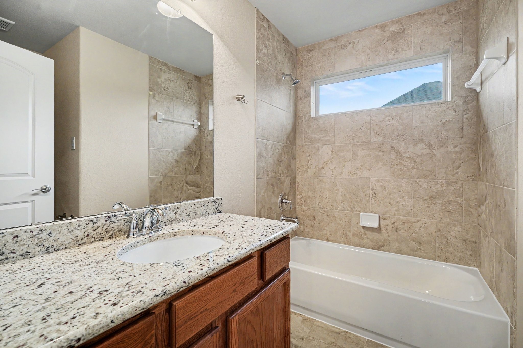 A full sized secondary bathroom complete with cabinets and drawers for storage, and a shower/tub combination with tile surround!