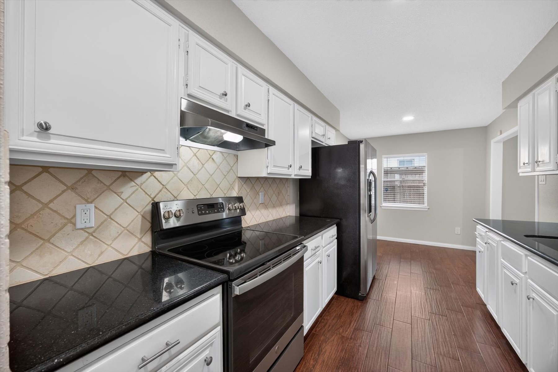 Electric range with granite counters offer plenty of cook space.