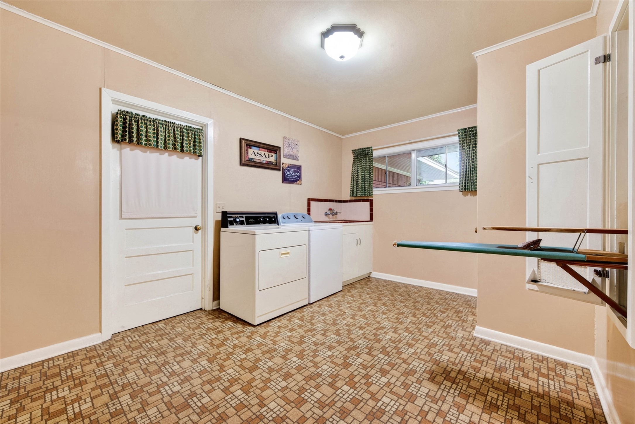 Laundry/mud room with foldout ironing board and sink