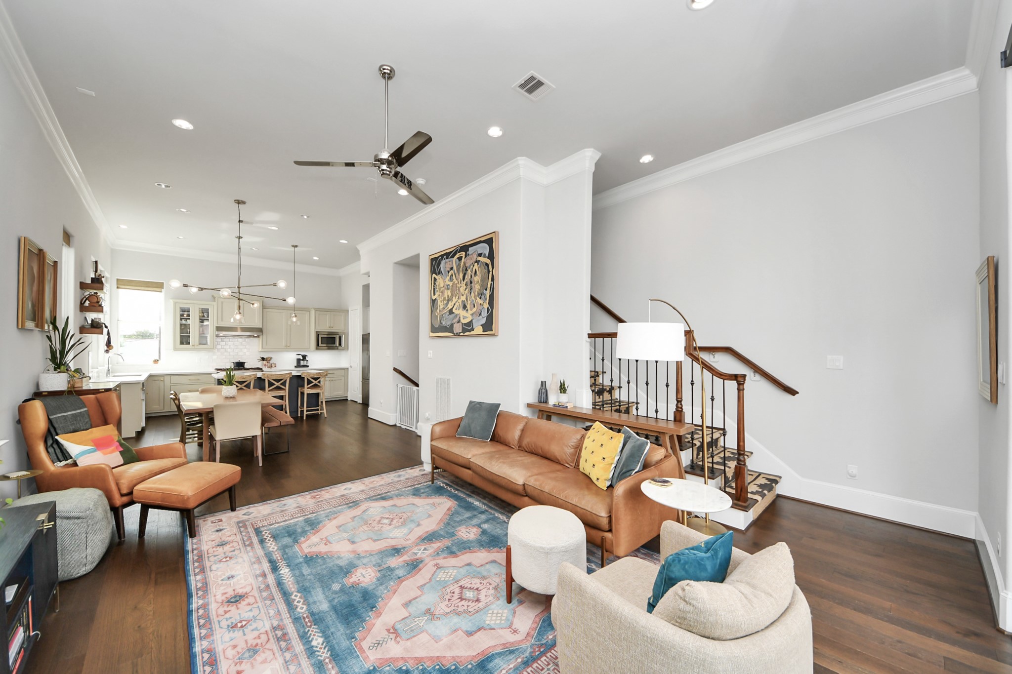 Spacious open-concept living area with elegant hardwood floors, modern kitchen, and stylish decor, perfect for entertaining and relaxation.