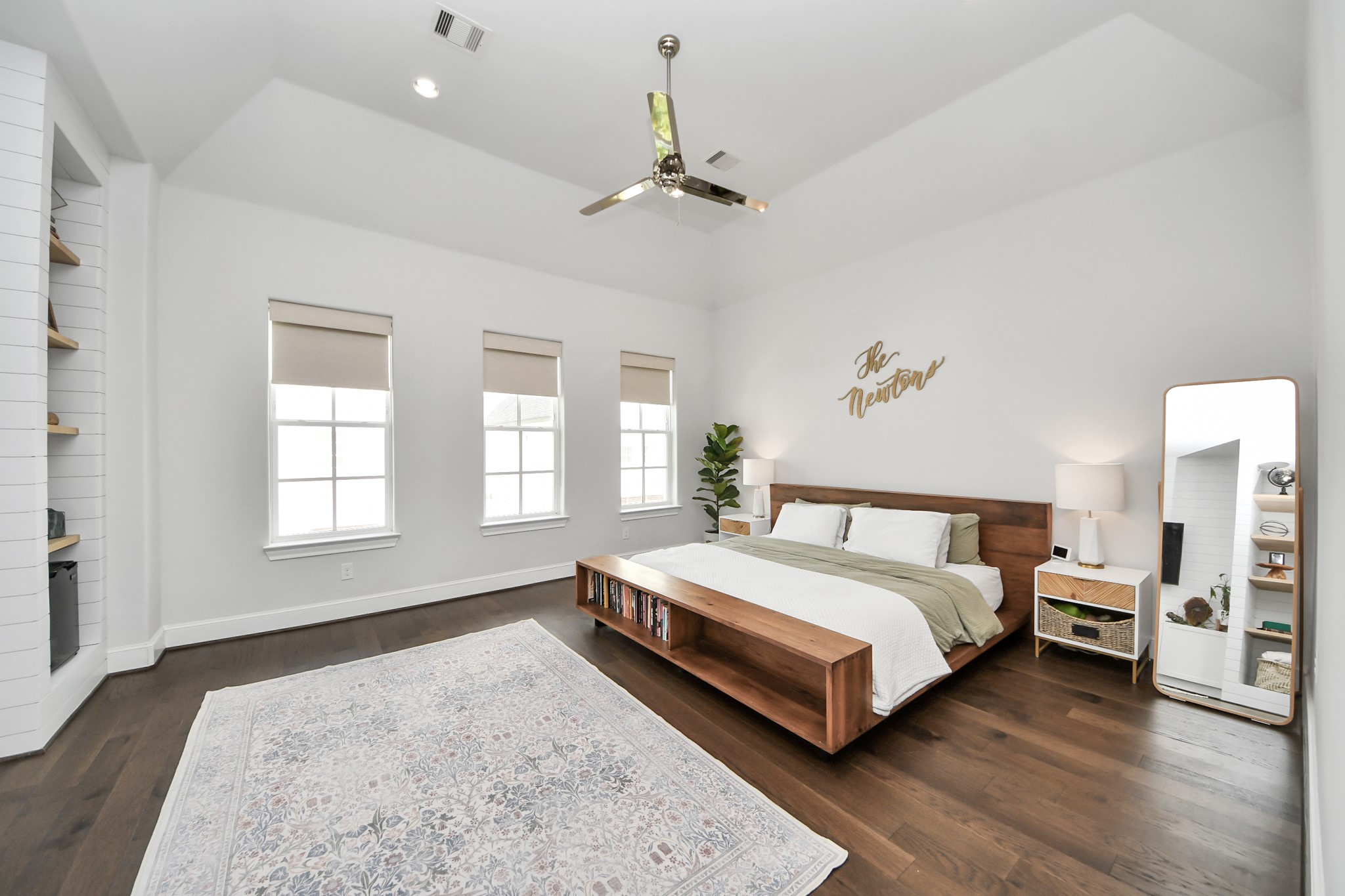 Spacious and bright primary bedroom featuring high ceilings, elegant hardwood floors, and large windows for natural light.