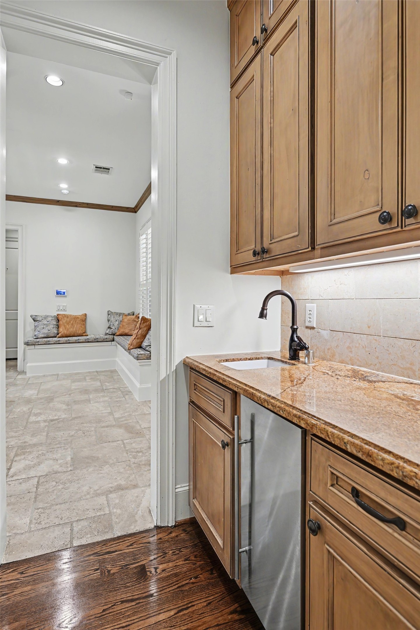 The butlers pantry features a beverage refrigerator, sink, serving counter, and additional cabinetry for added convenience when entertaining.
