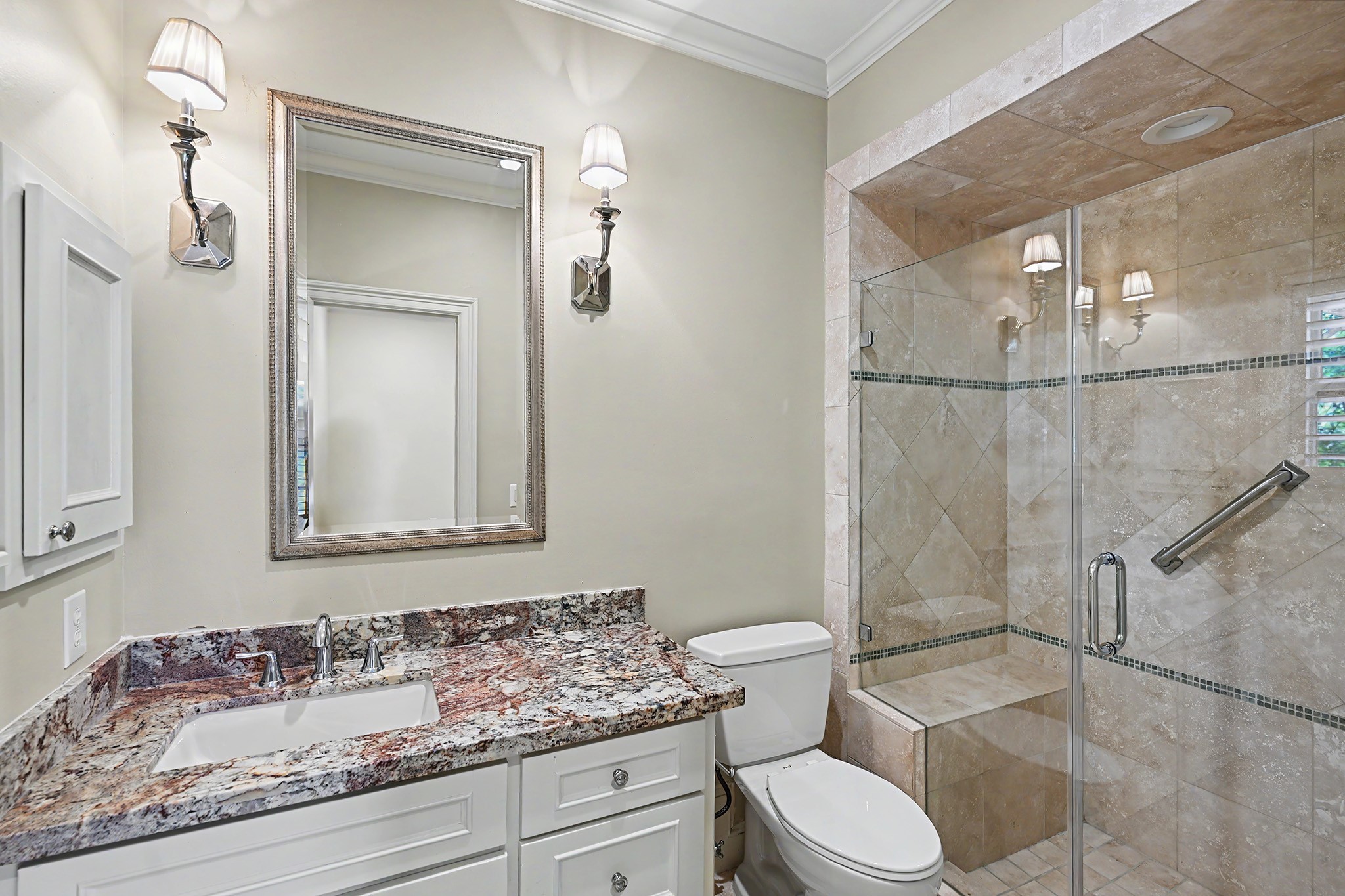 The ensuite bathroom includes a glass-enclosed walk-in shower with a built-in bench.