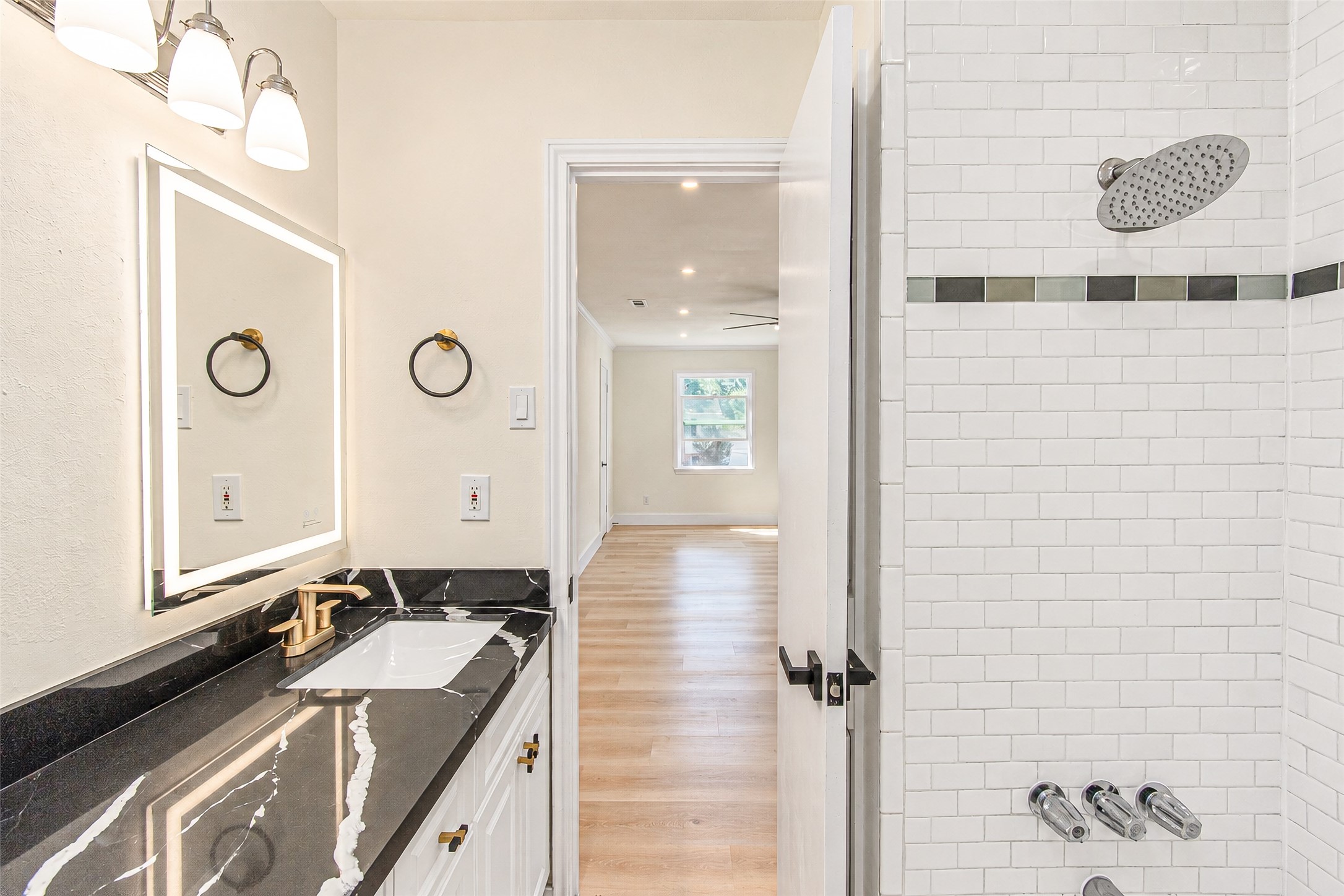 Elegant primary bath featuring a luxurious black quartz countertop, modern fixtures, and a stylish tiled shower for a spa-like retreat.