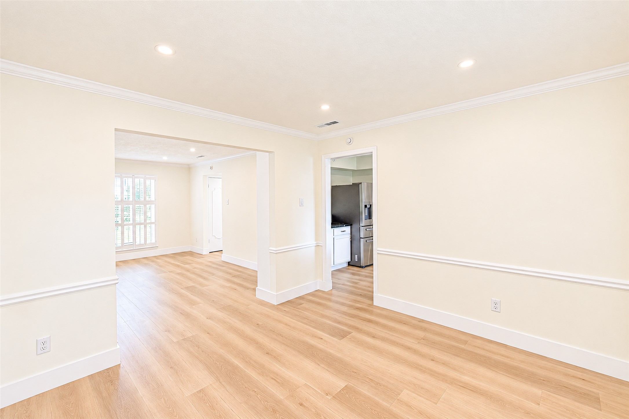 Bright and inviting dining room with elegant vinyl flooring and seamless access to the kitchen, perfect for hosting memorable gatherings.