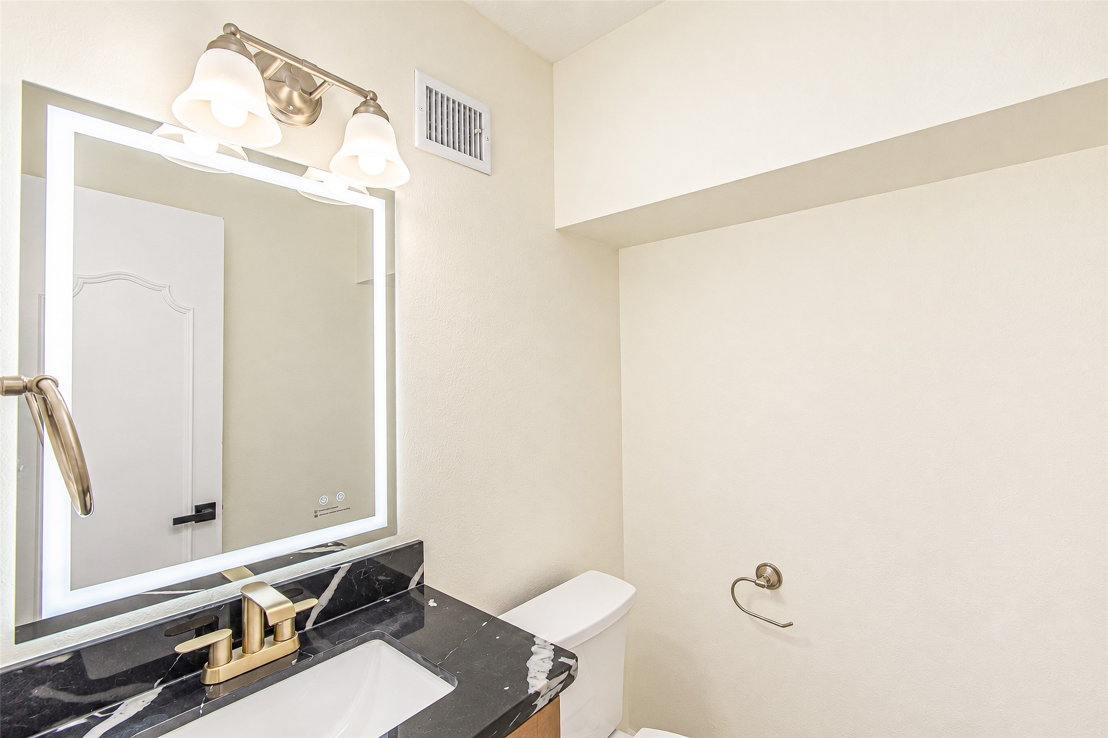 Elegant powder room featuring a sleek quartz marble countertop, modern fixtures, and ambient lighting for a sophisticated touch.
