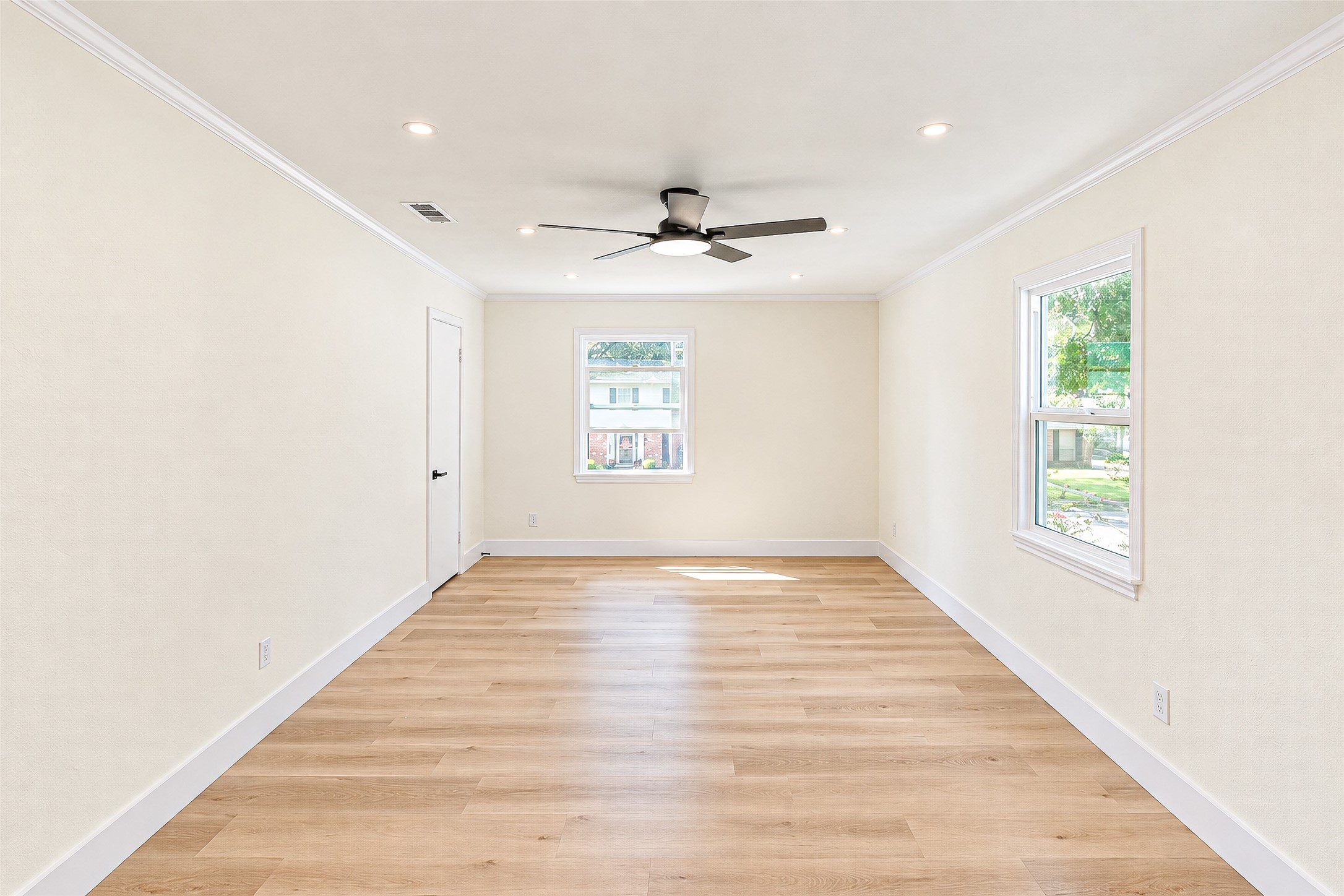 Experience tranquility in Bedroom 2, featuring ample natural light, elegant vinyl floors, and a modern ceiling fan for ultimate comfort.