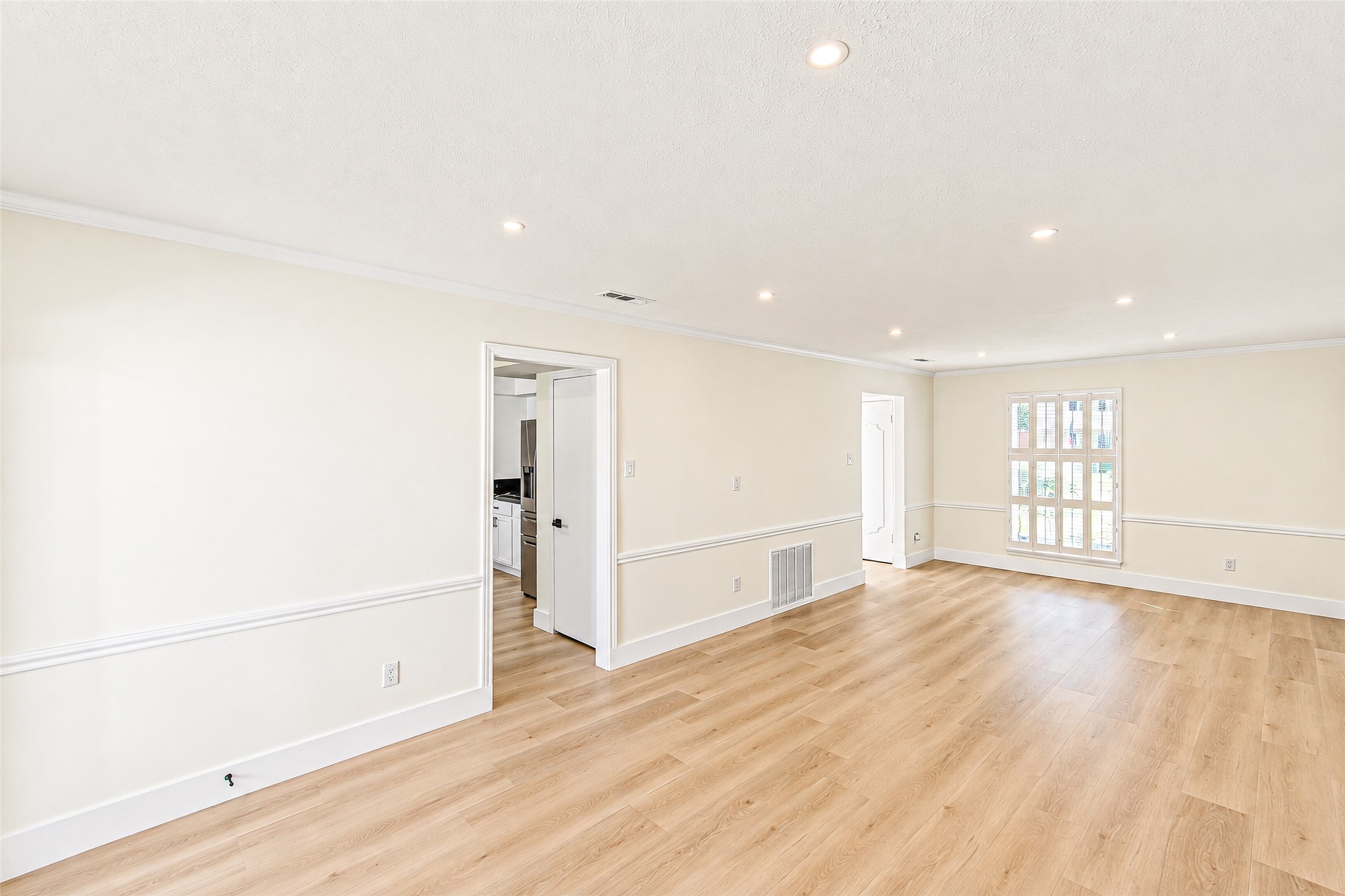 Bright and inviting, this expansive living area features elegant vinyl flooring, recessed lighting, and ample natural light, creating a perfect space for relaxation and entertaining.