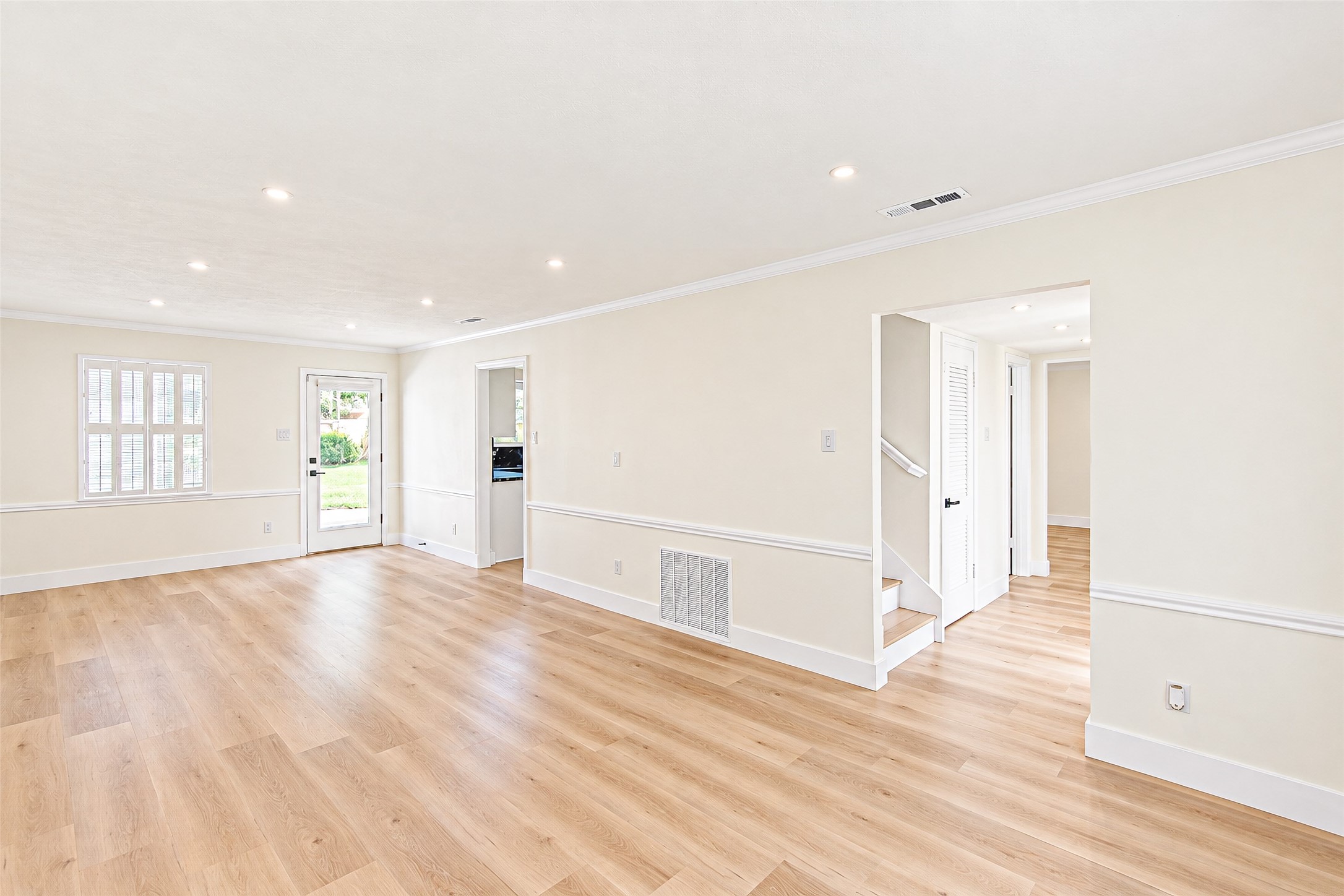 Bright and spacious living room featuring elegant vinyl flooring, abundant natural light, and seamless access to outdoor views.