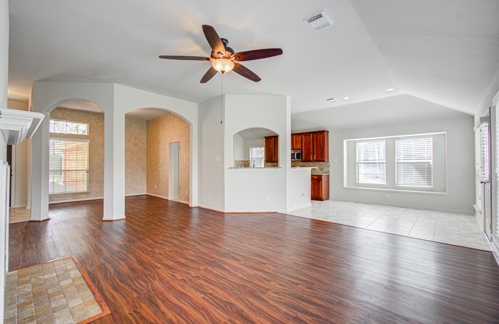 Spacious open-concept living area seamlessly connecting to a modern kitchen with rich cabinetry and a cozy dining nook.