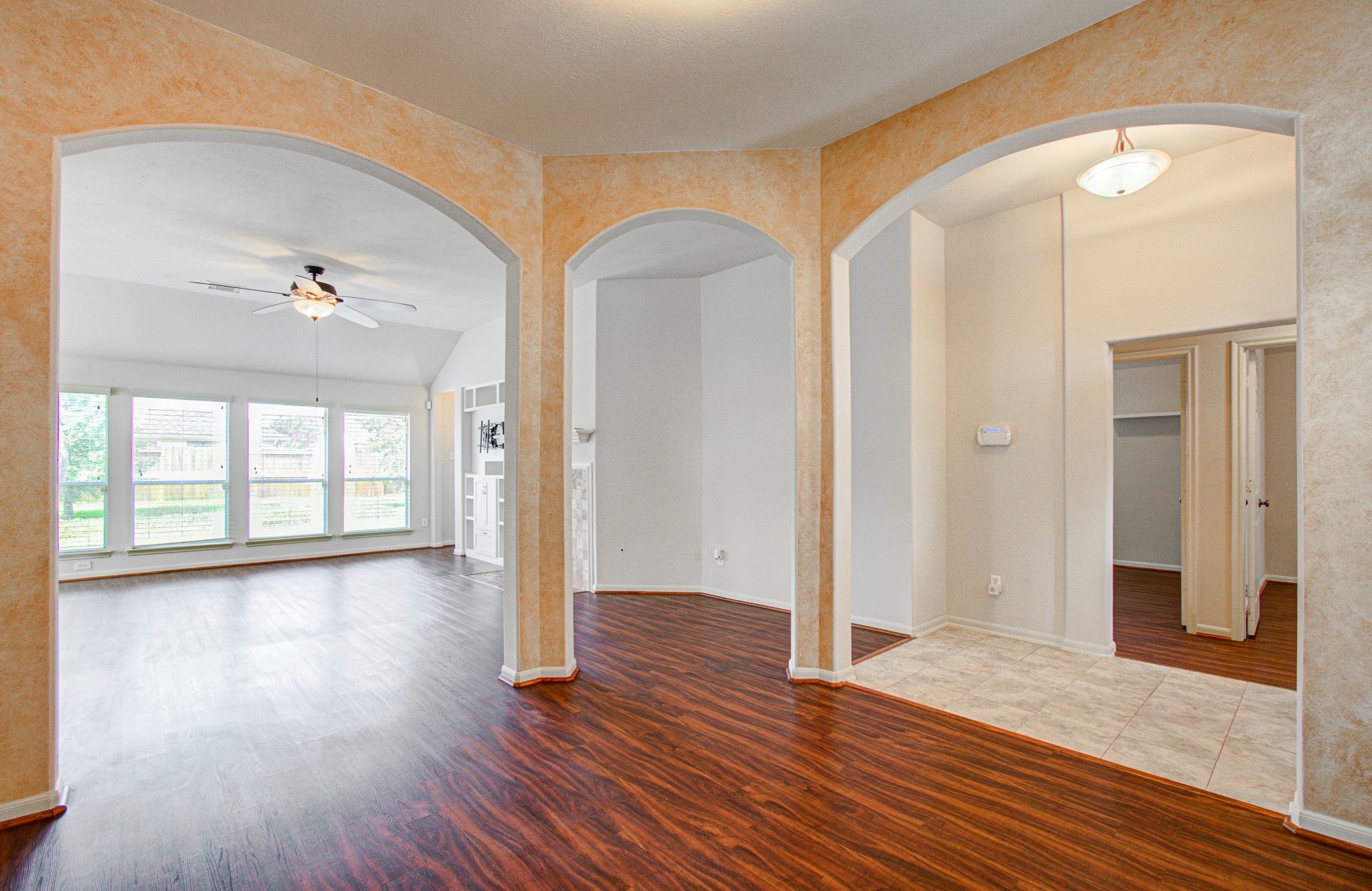 Elegant arched doorways and large windows provide ample natural light for this dining/sitting area.