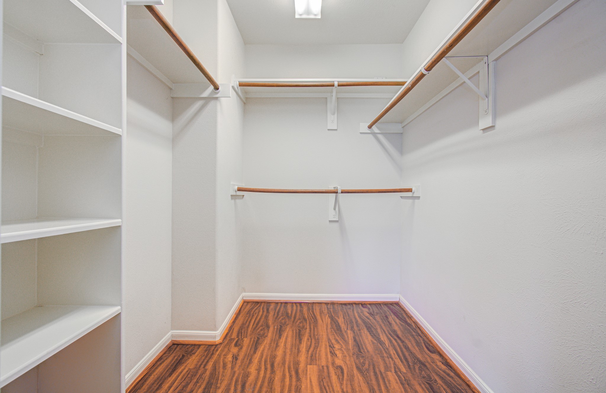 Primary walk-in closet with ample shelving and hanging space.