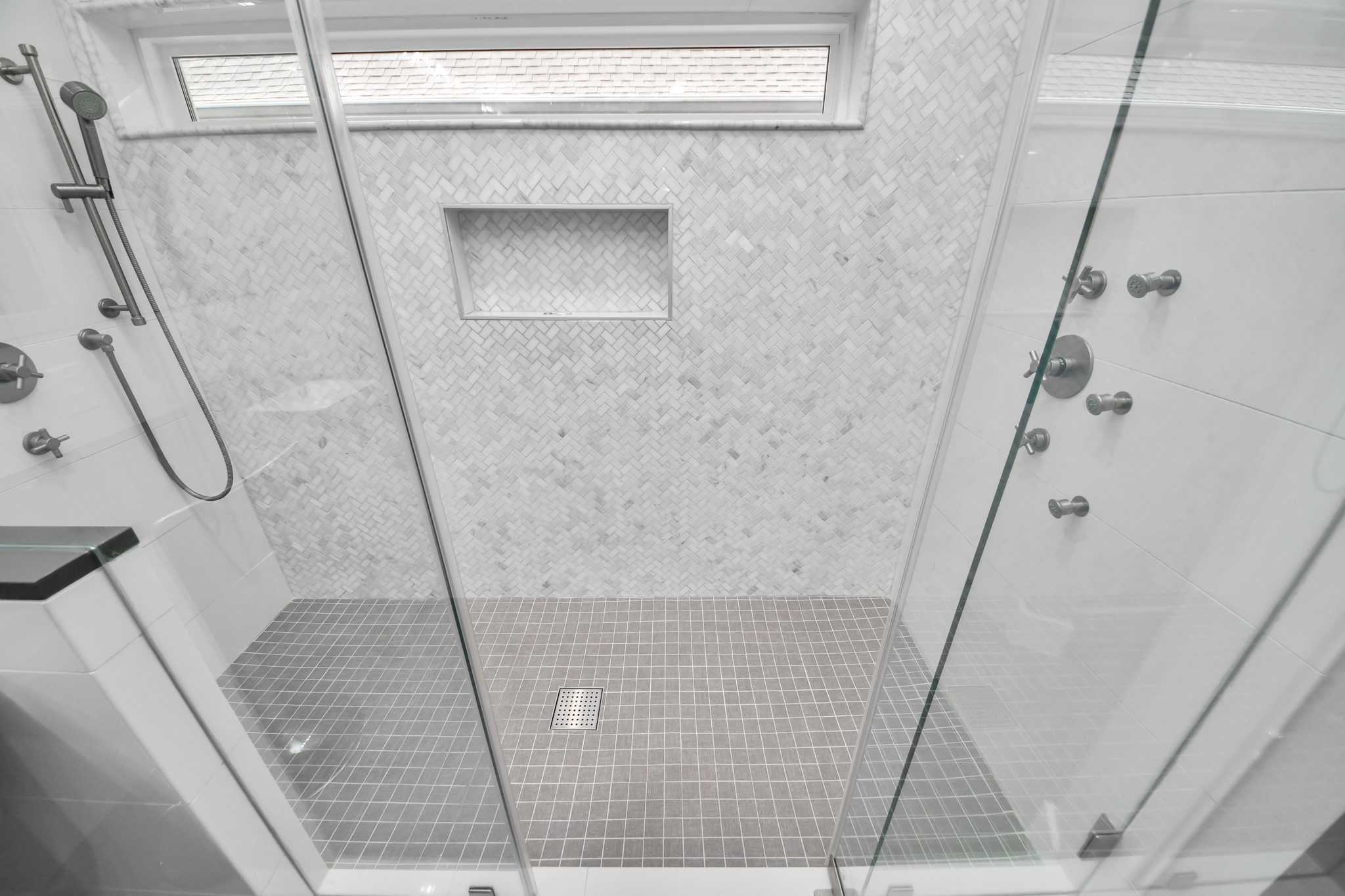 Luxurious custom shower in the primary bedroom featuring body sprayers, wands and custom set temperature controls on both sides for the perfect shower, every time!