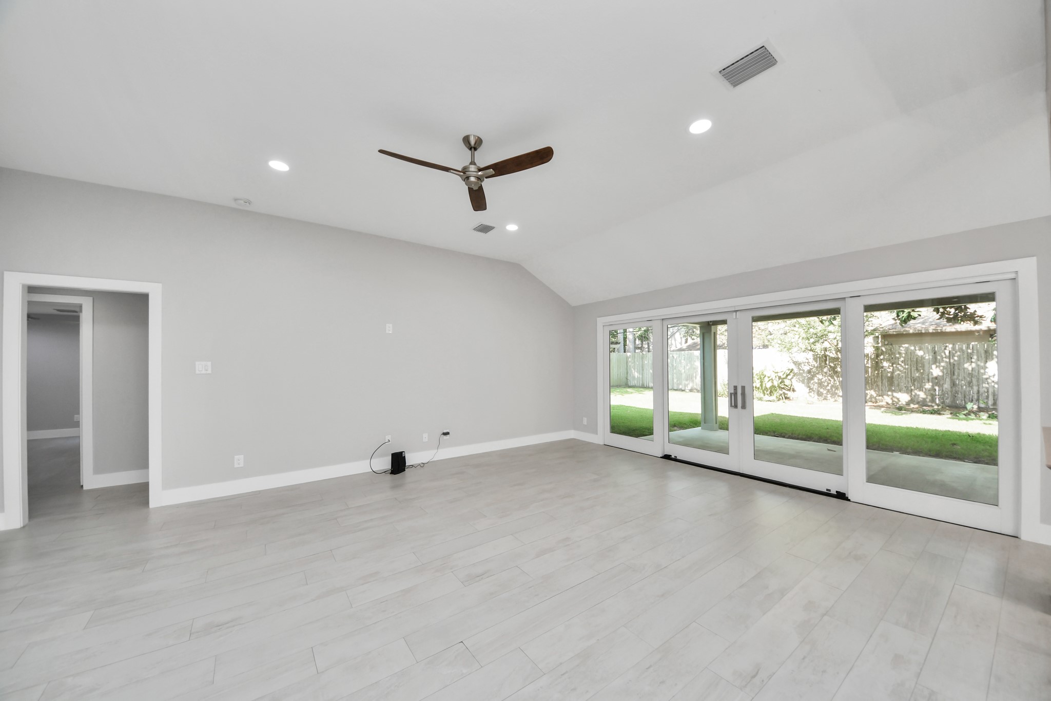 Spacious living room/great room showcasing a gorgeous sliding door and seamless ceramic tile flooring