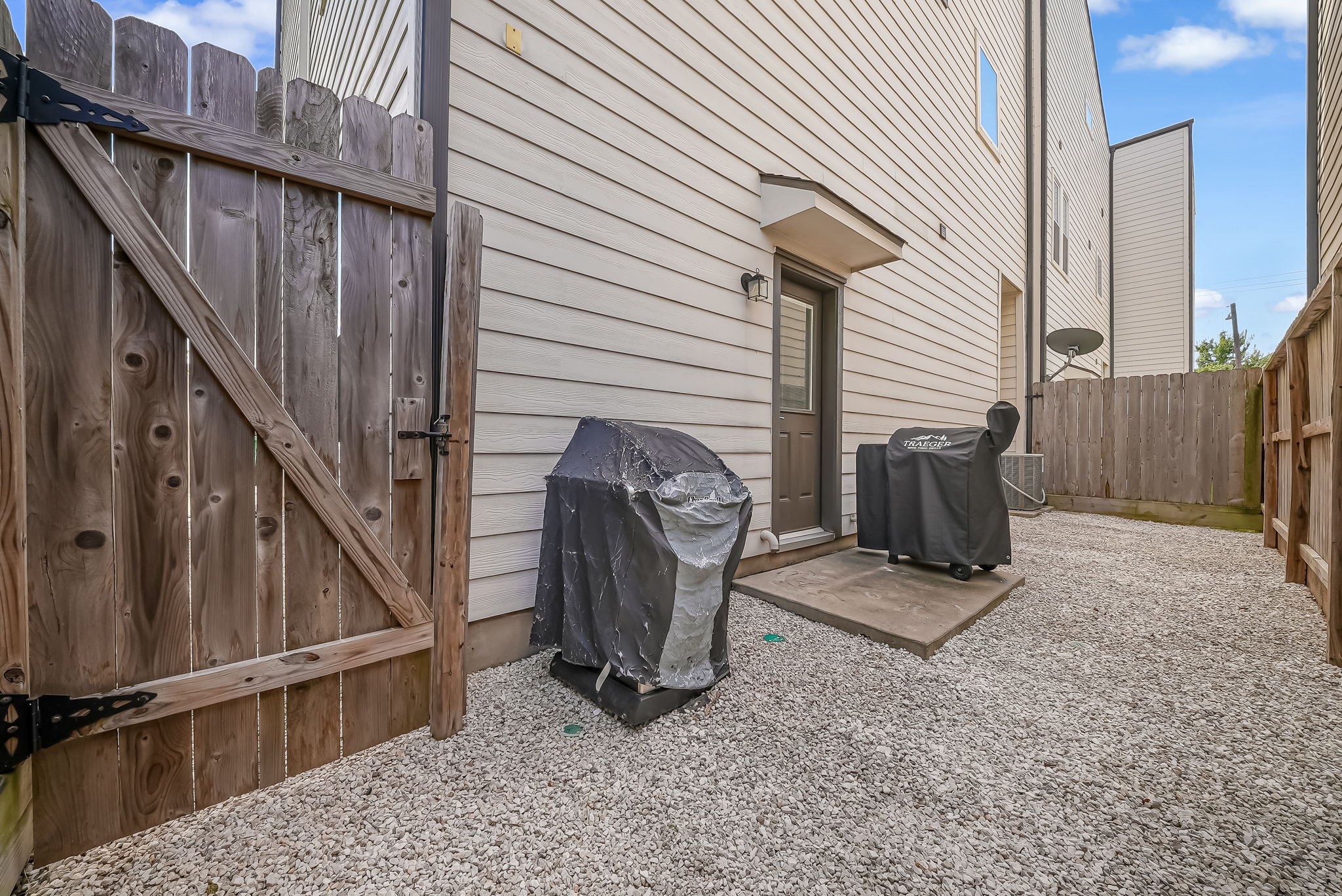 Low-maintenance backyard with gravel landscaping and space for outdoor dining or grilling.