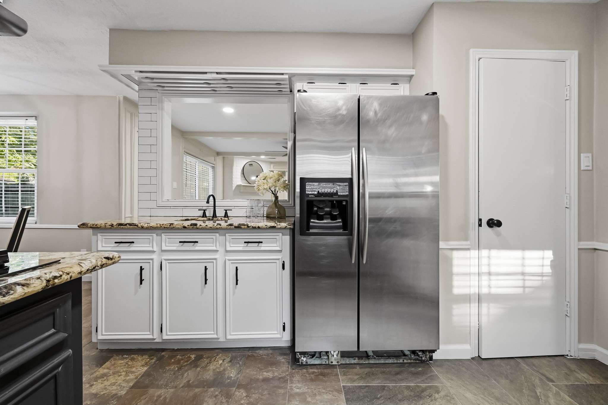 Modern kitchen featuring sleek stainless steel appliances, granite countertops, and crisp white cabinetry, offering a sophisticated and functional space.