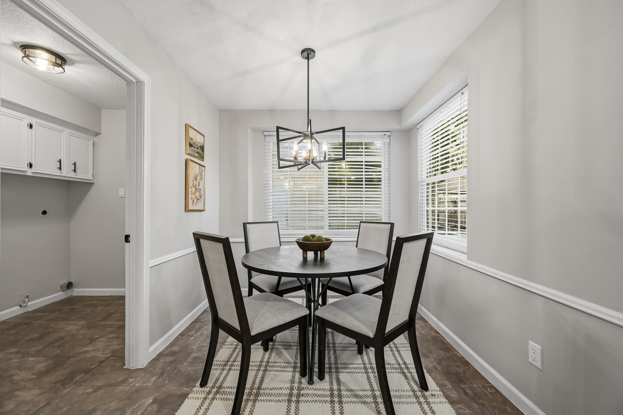 Bright and inviting breakfast nook featuring a round table with seating for four, accented by large windows that provide abundant natural light.