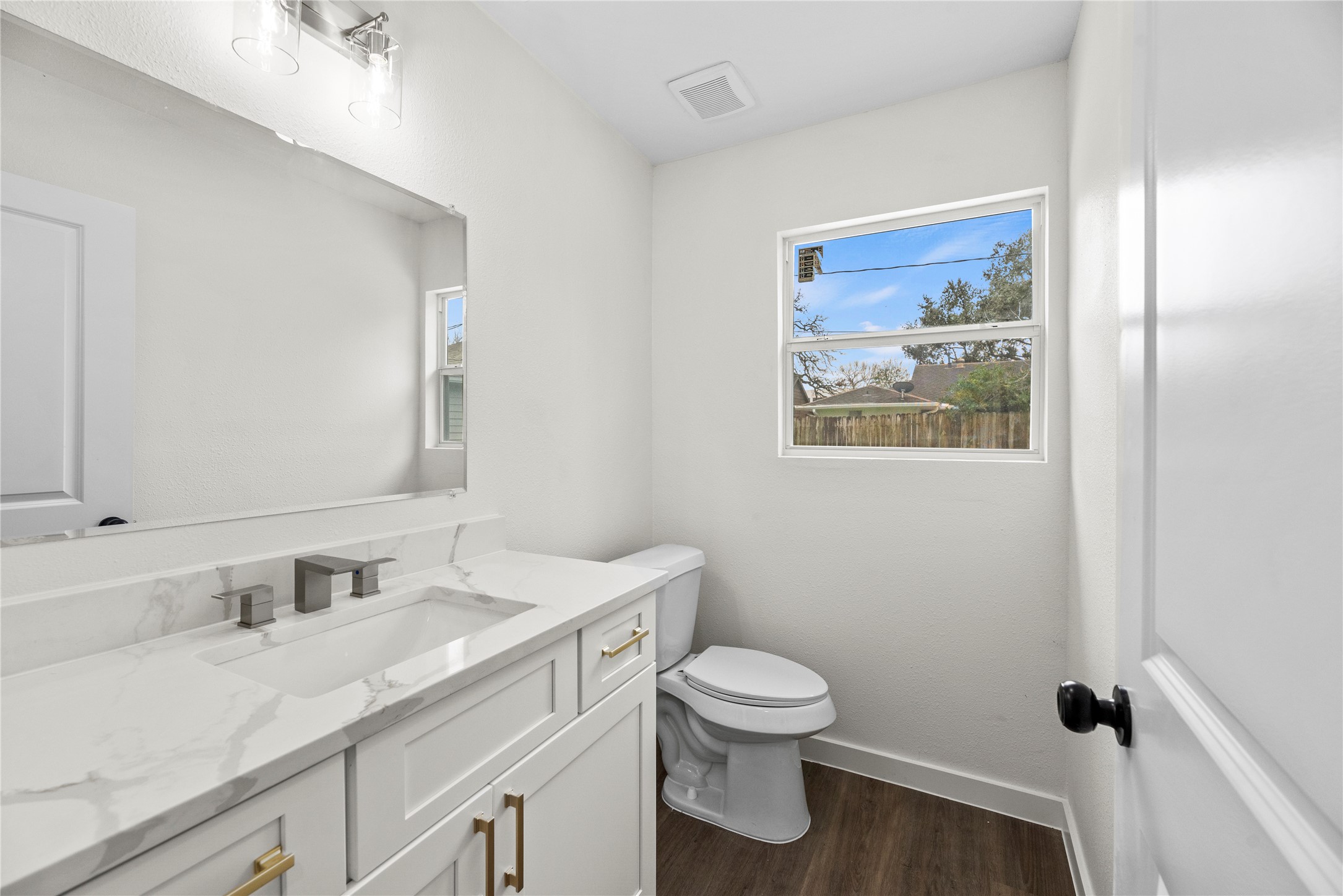 Downstairs half bathroom with a new vanity, hardware and fixtures.