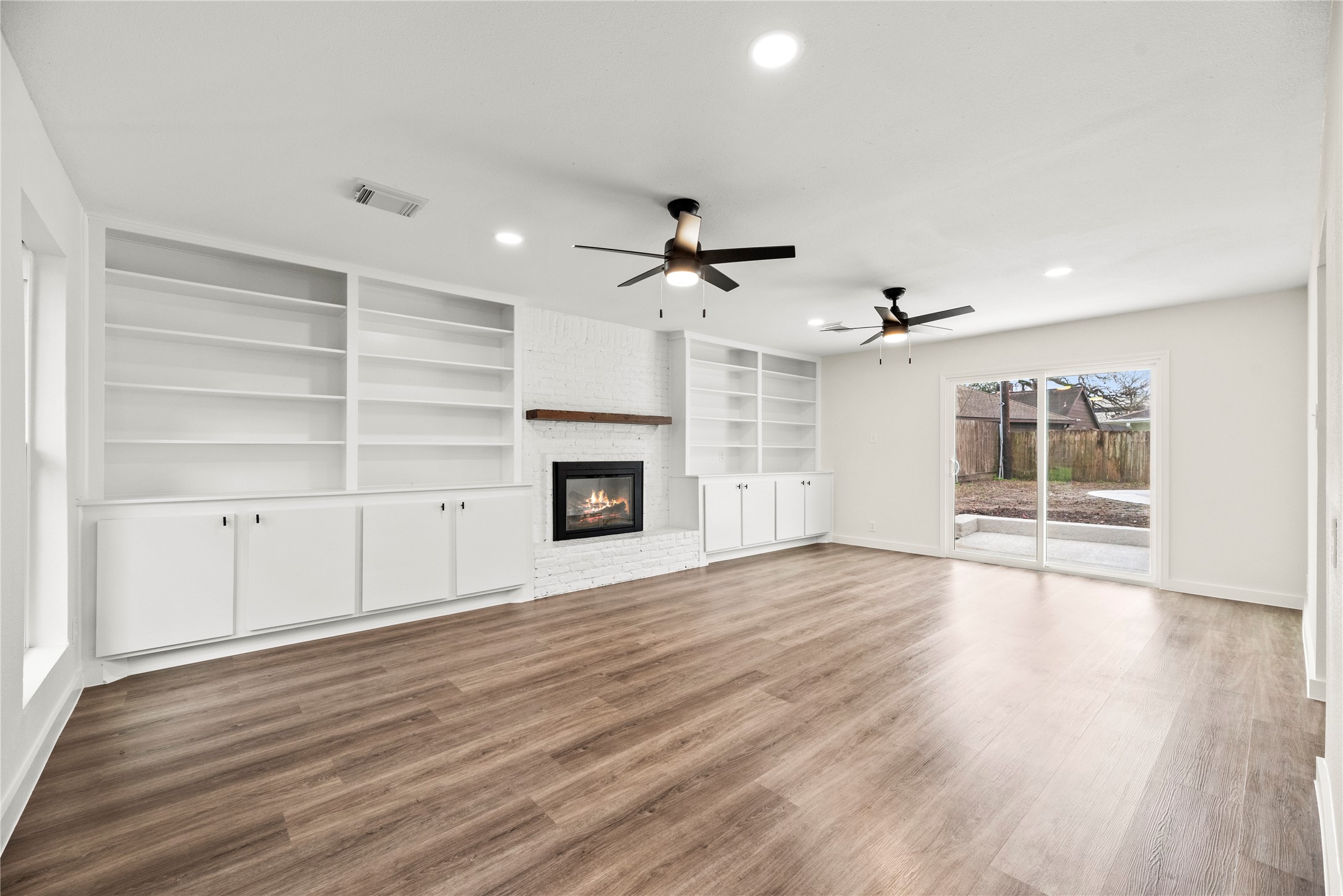 Spacious family room with LVP flooring, custom built-ins and a cozy fireplace.