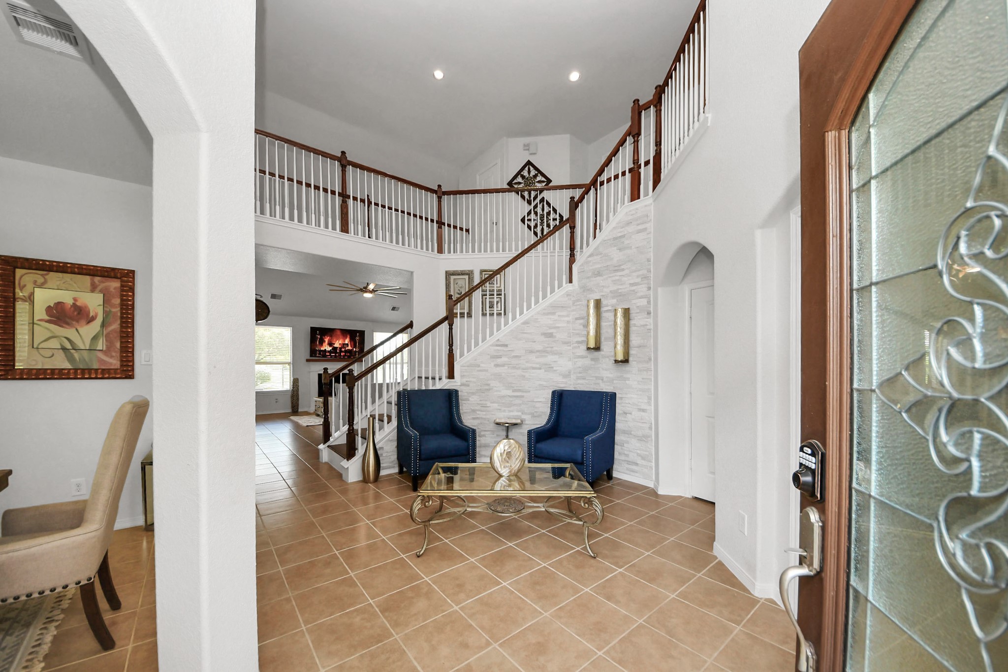 Grand foyer with soaring ceiling and an elegant staircase welcomes you into this stunning lakefront home