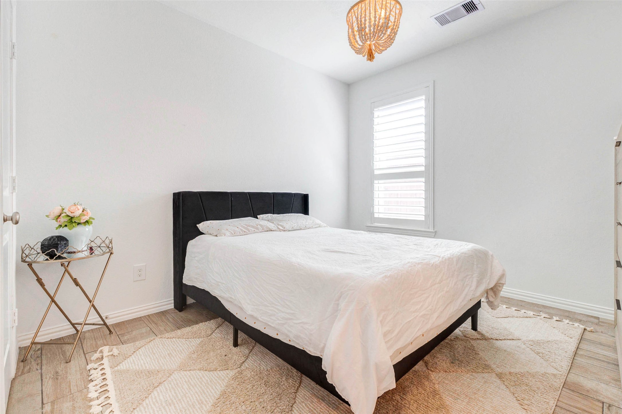 This charming secondary bedroom offers comfort and simplicity, with a neutral color palette ready for personalization. Natural light fills the room through the window, creating a bright and inviting space. The layout provides room for furnishings while keeping a cozy feel, and the space could also serve as a home office.