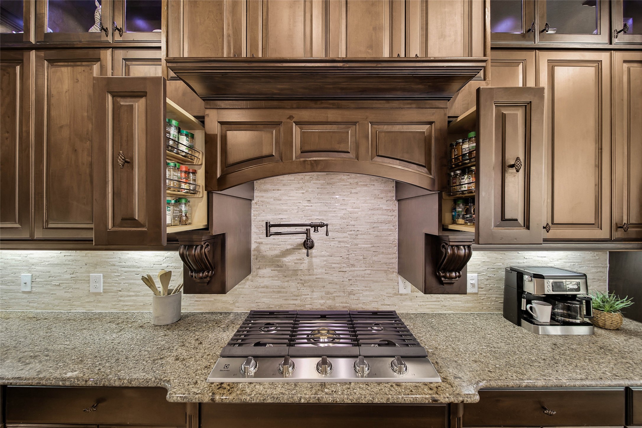 Two convenient pull-out spice racks on either side of the cooktop keep your favorite seasonings within easy reach when preparing your famous recipes.... AND dont forget the handy pot filler above the cooktop, adding a touch of chef-inspired luxury and everyday practicality to this exceptional kitchen! Electrolux Cooktop (2026).