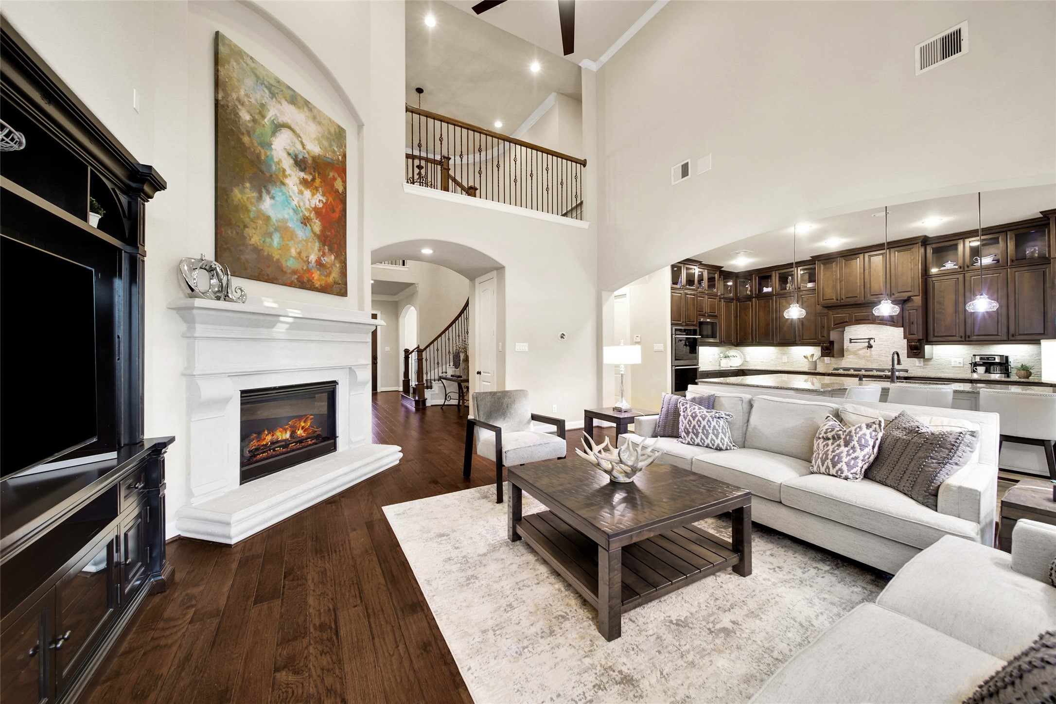 The spacious living room boasts soaring ceilings that enhance the open, airy feel, while built-in sound wiring sets the stage for the perfect entertainment experience.